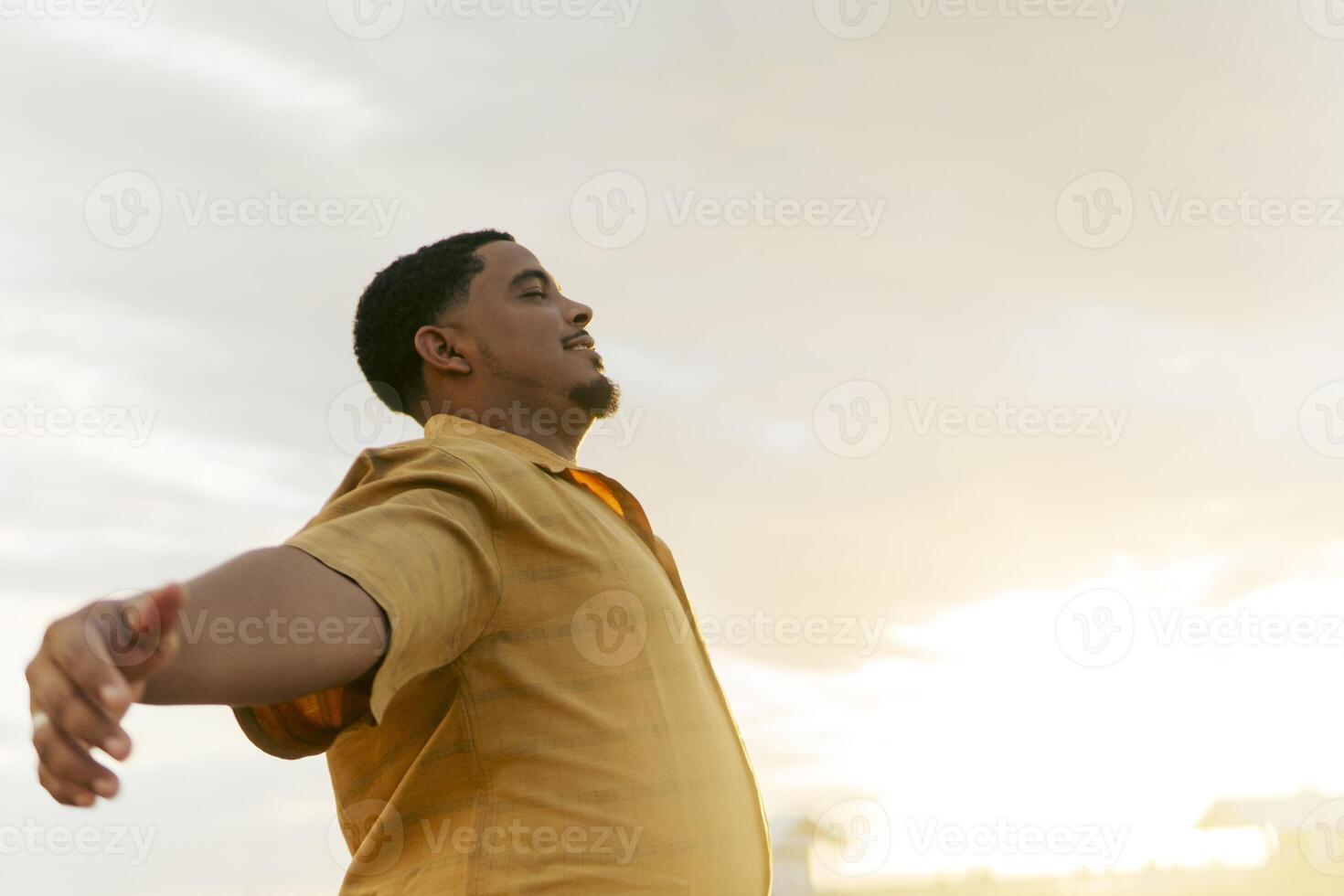 Tourist enjoying freedom with open arms under sunset sky photo