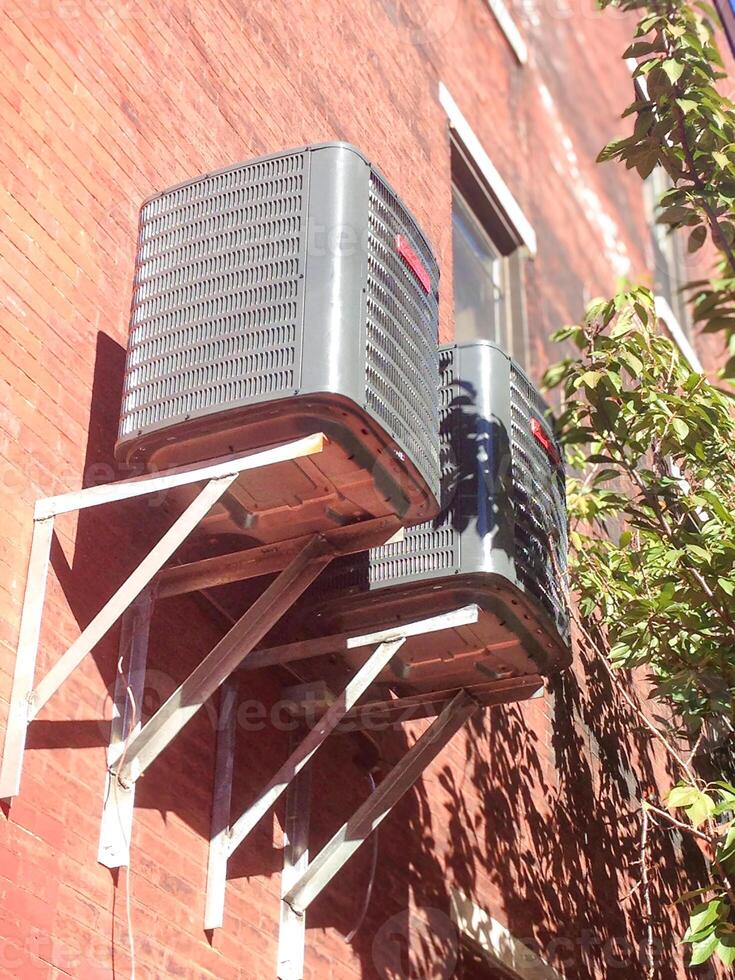 Dual Wall-Mounted Outdoor HVAC Units on Brick Building photo