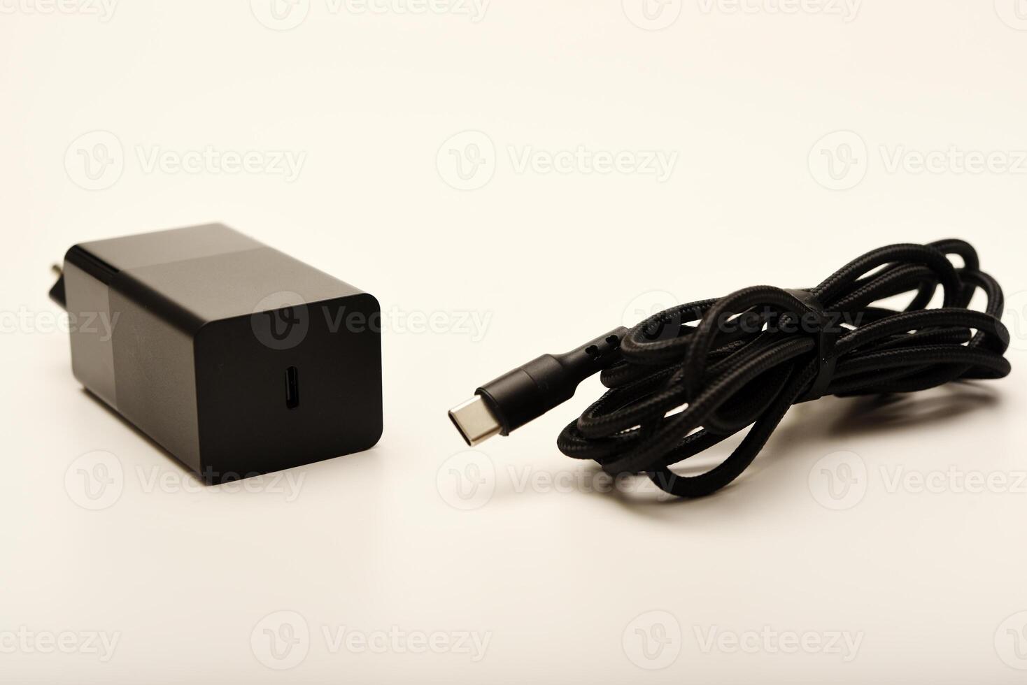 Phone charger with coiled cable on white. A new charger for gadgets with a wire. USB charging with a wire. photo