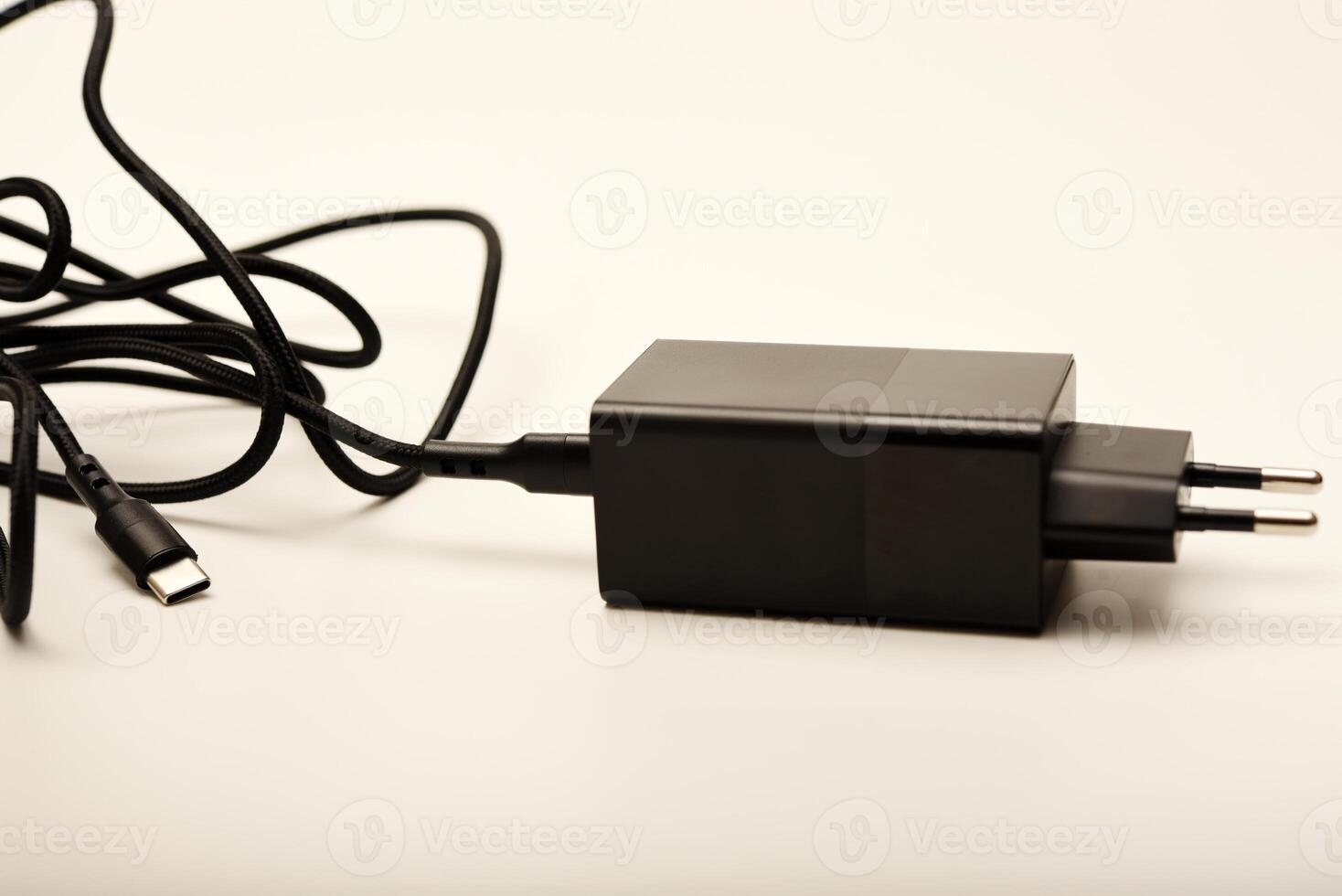 Smartphone charger with cable on white. A new charger for gadgets with a wire. USB charging with a wire. photo