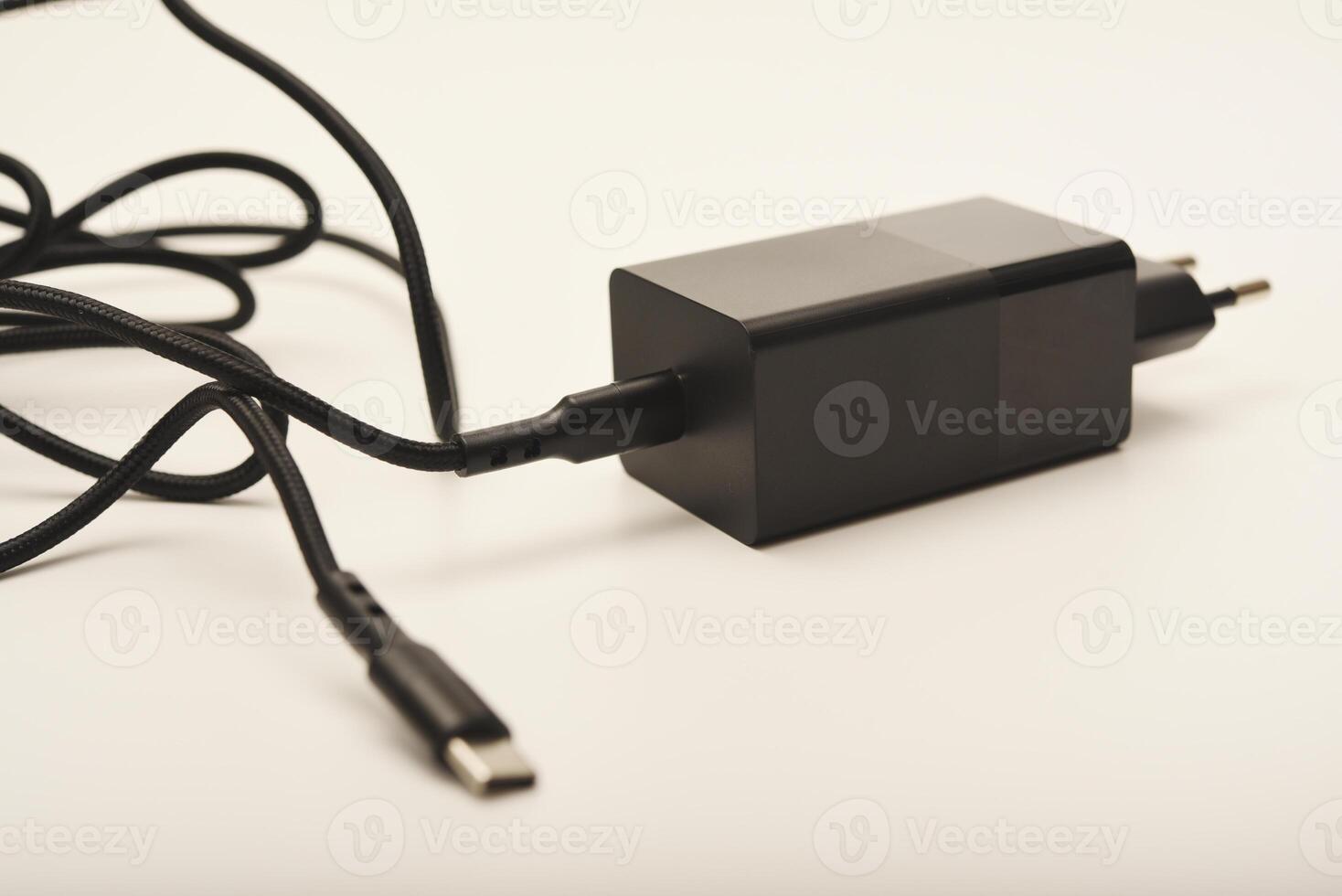 Black charging plug with white cable. A new charger for gadgets with a wire. USB charging with a wire. photo