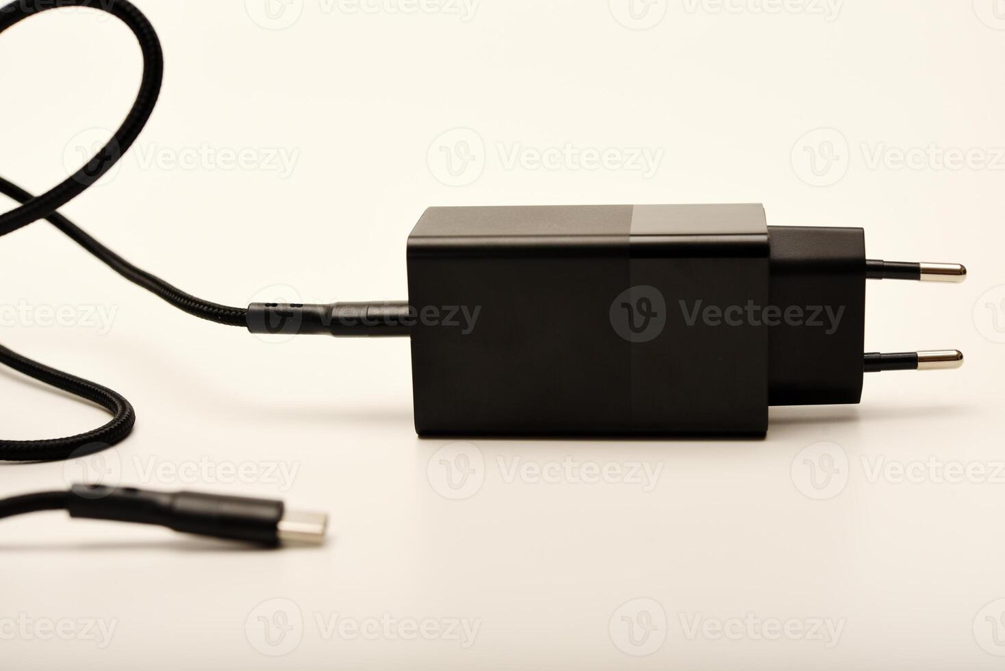 Minimalist black power adapter on white. A new charger for gadgets with a wire. USB charging with a wire. photo