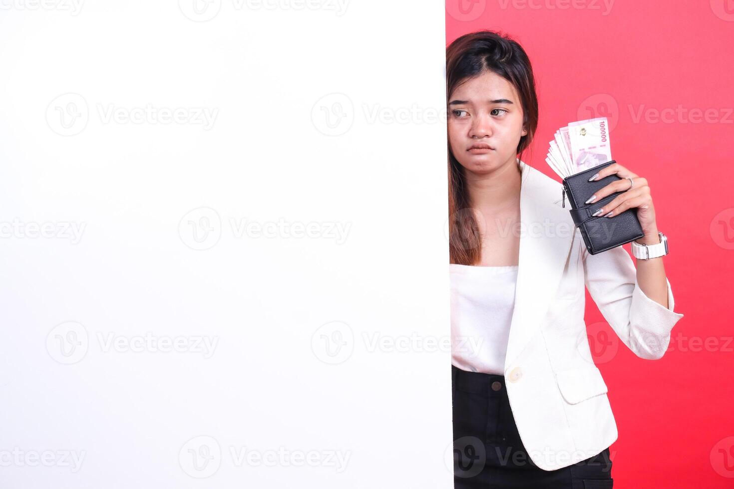 Woman with money behind a white wall photo