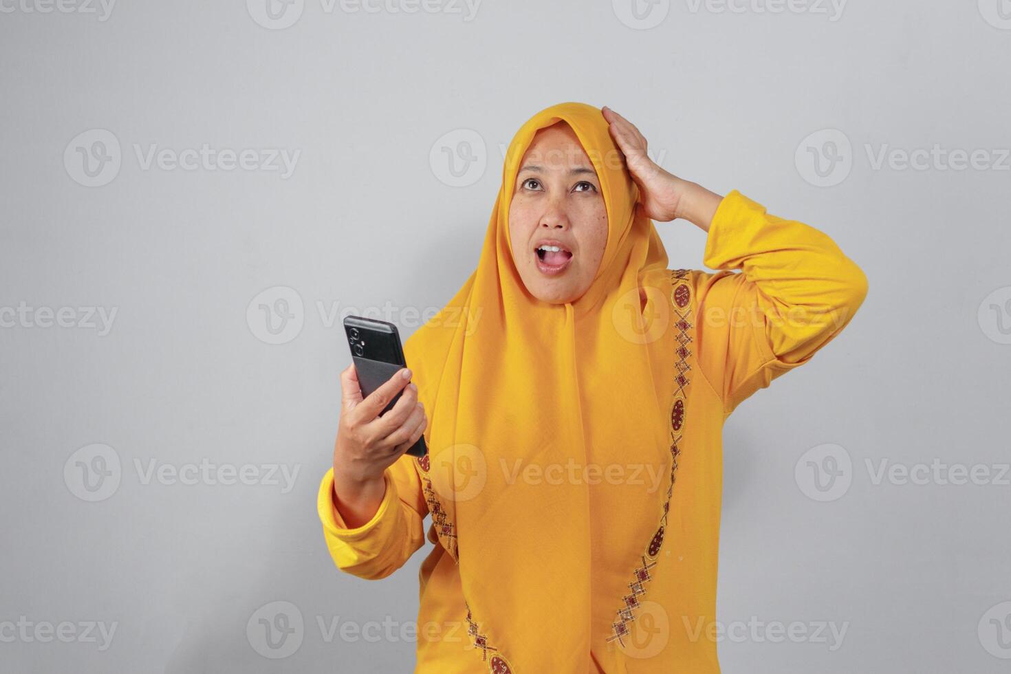 Surprised Muslim woman reacting to unexpected news on phone photo