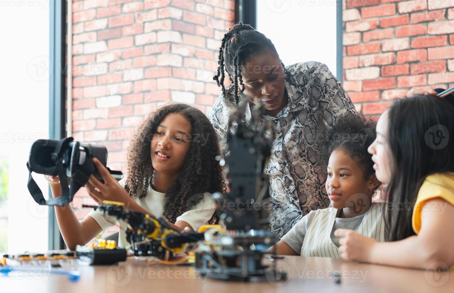 Girls Engaged in STEM Learning with Robotics and VR, Diverse Students and Teacher Exploring Technology and Engineering, Young Innovators Building and Learning with Robotics photo