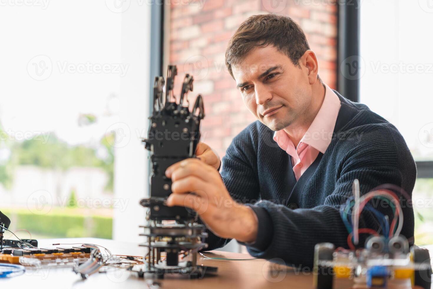 Robotics Engineer Working on Advanced Prosthetic Arm, Man Assembles Bionic Hand Prototype, Scientist Developing Robotic Limb, Innovation in Progress photo