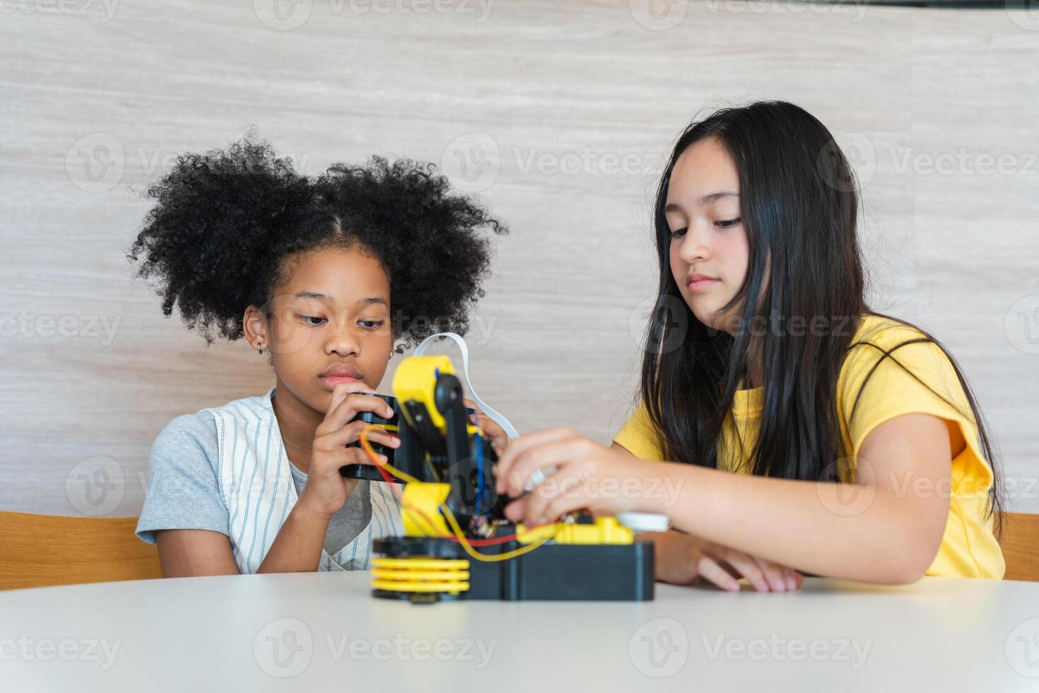 Young Girls Engaged in Robotics and STEM Learning, Diverse Kids Building a Robot Arm in a Science Workshop, Two Girls Exploring Technology and Innovation, Future Engineers photo