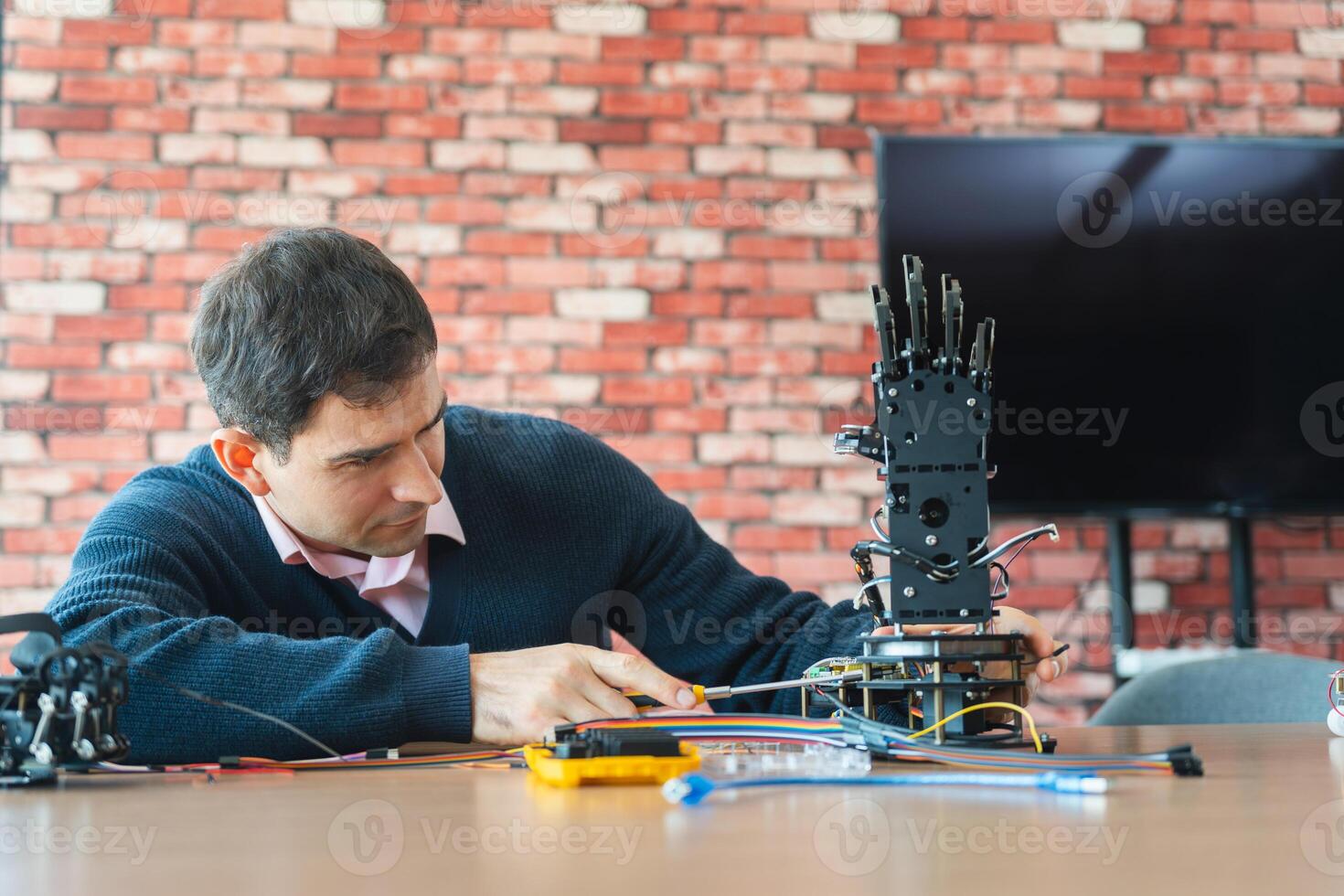 Robotics Engineer Working on Advanced Prosthetic Arm, Man Assembles Bionic Hand Prototype photo
