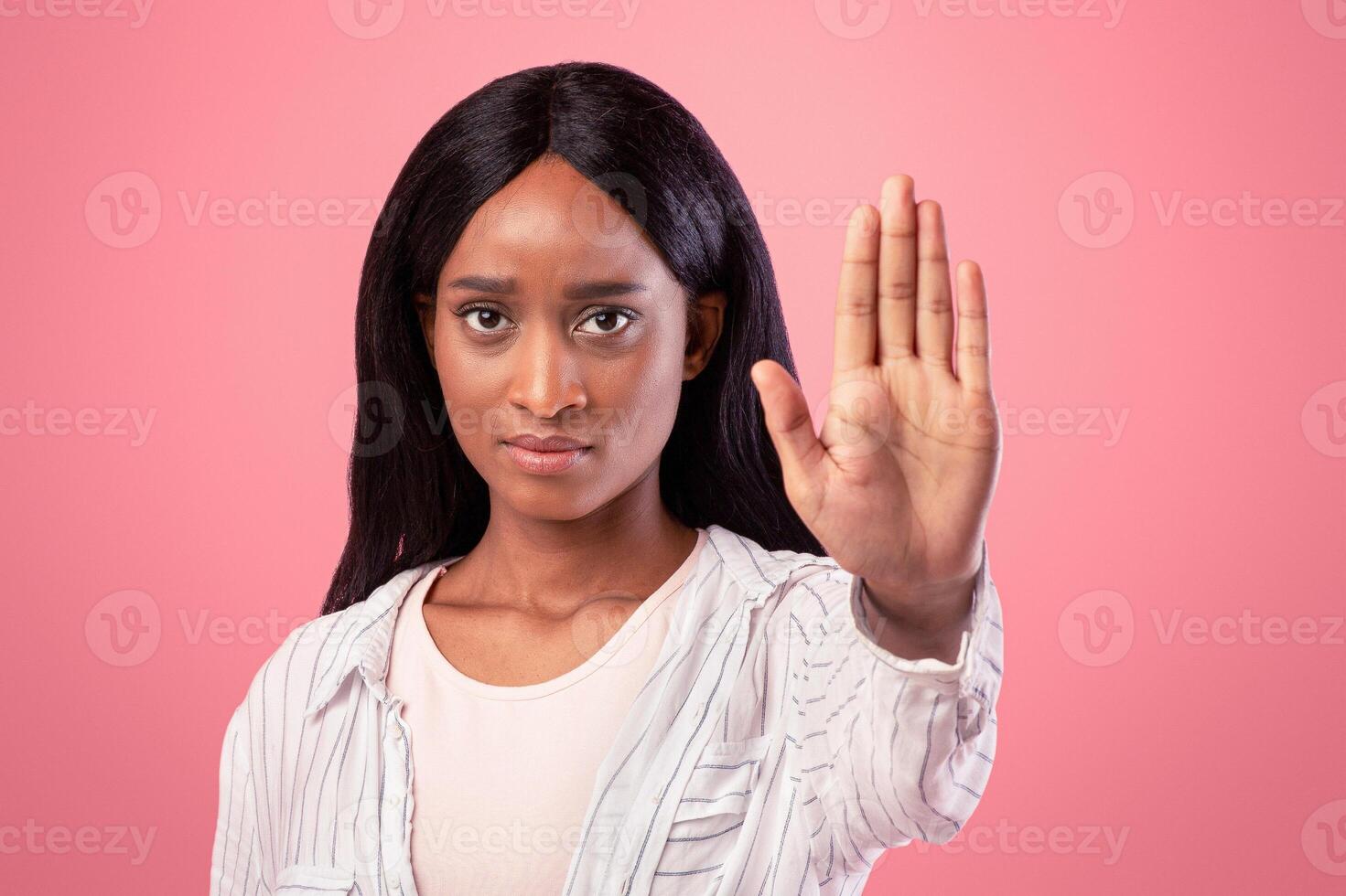 Thank you but no concept. Serious black woman making stop gesture on pink studio background. Assertive African American woman showing denial sign, expressing her rejection, refusing something photo