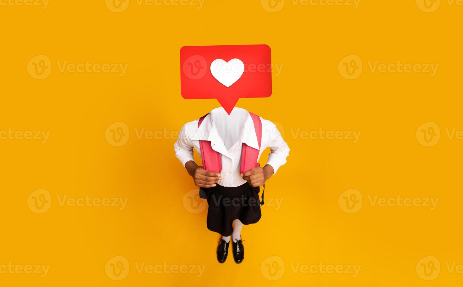 A child in a school uniform holds a backpack with large heart icon instead of their head. The bright yellow background enhances the lively atmosphere, symbolizing social media interaction. photo