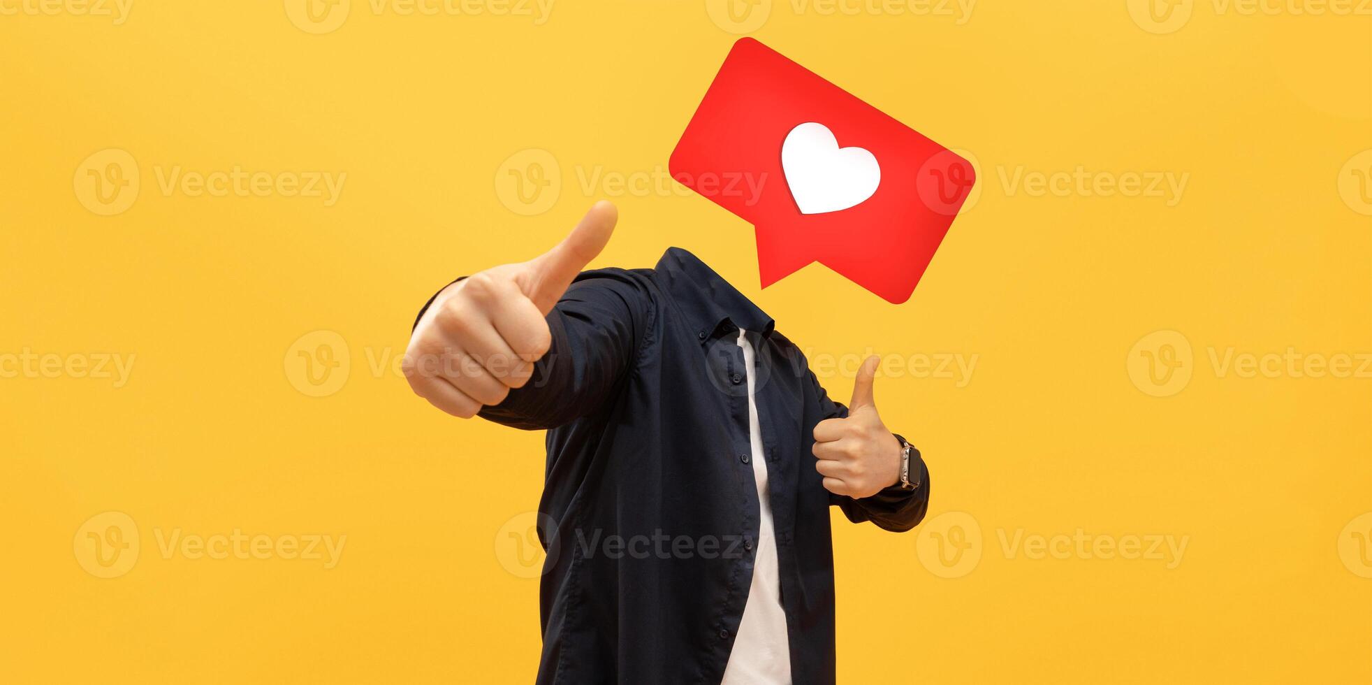 A person gives a thumbs up in front of a bright yellow background, with a large heart icon instead of their head, symbolizing positive feedback on social media platforms. photo
