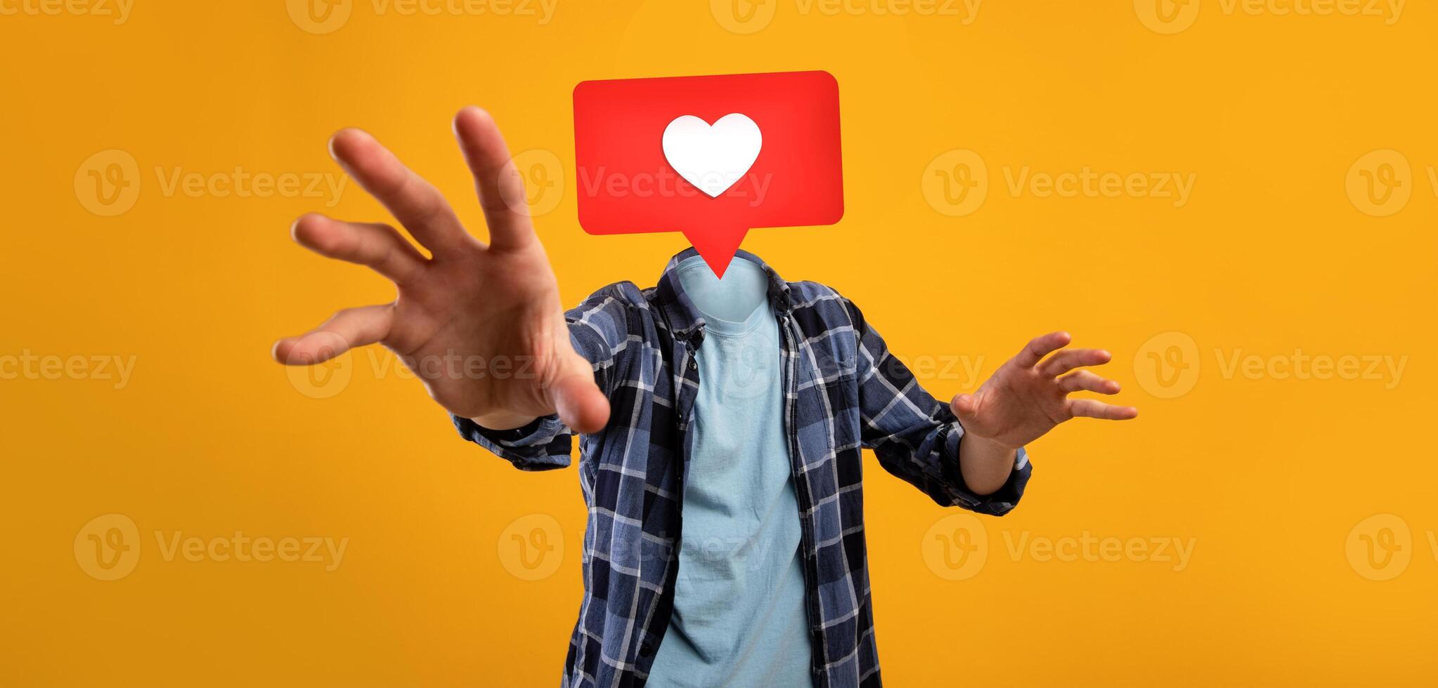 A person with a heart icon instead of a head reaches out with an enthusiastic gesture against a bright yellow background. This symbolizes the excitement of social media interactions. photo