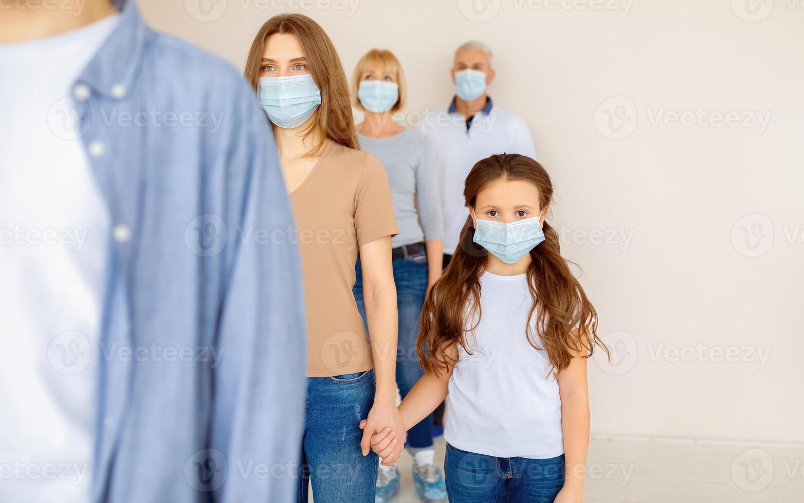 Parent and child in medical masks waiting in line for coronavirus vaccination at clinic. Covid-19 immunization, prevention of worldwide infectious disease outbreak concept photo