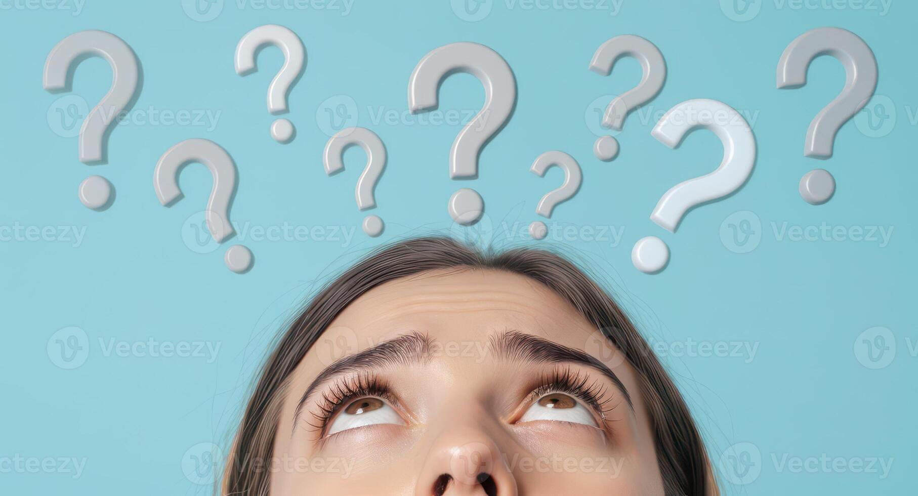 Young woman looking up at question marks, representing thought and inquiry photo