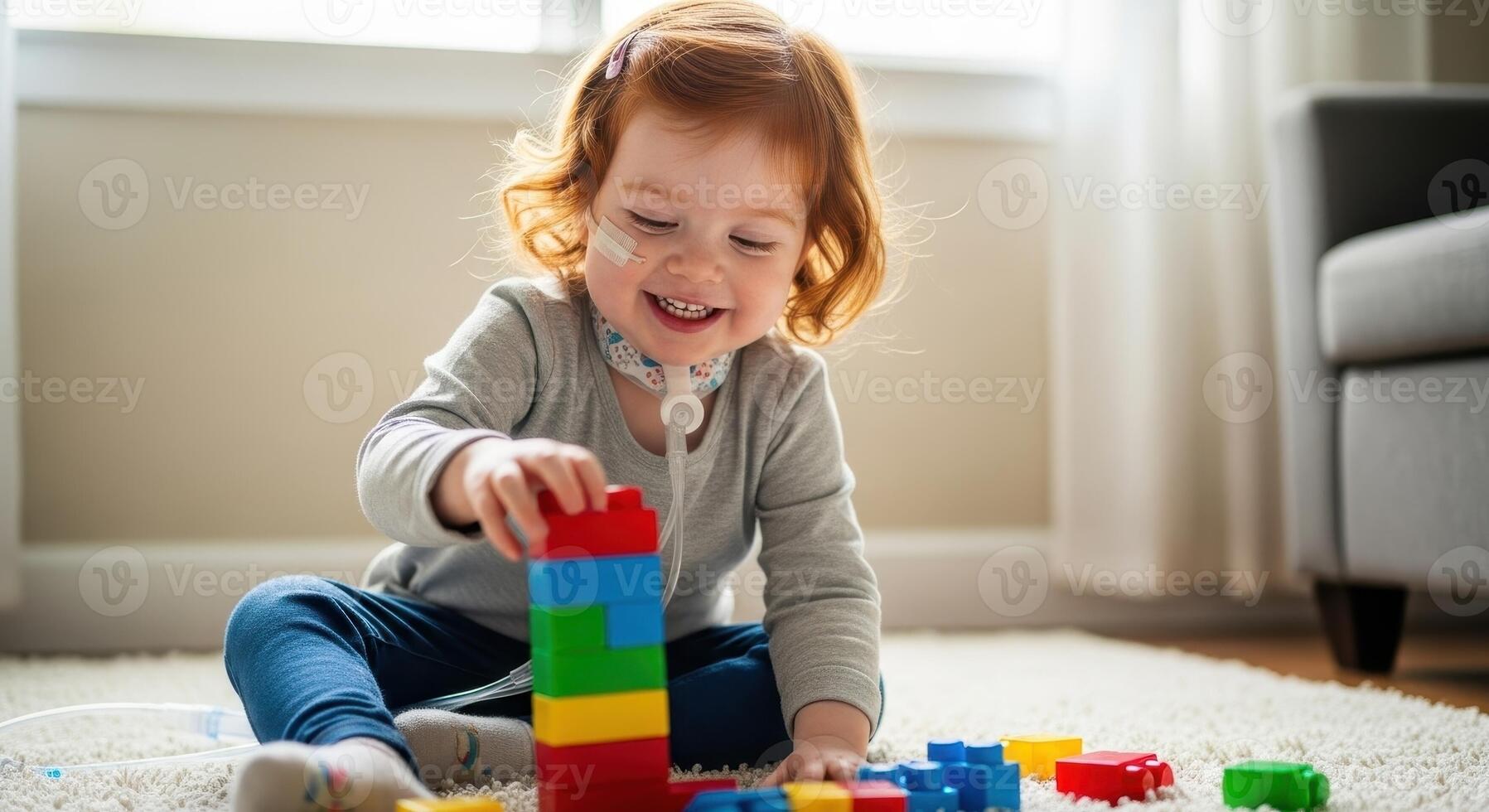 Joyful toddler girl with feeding tube playing with colorful building blocks photo