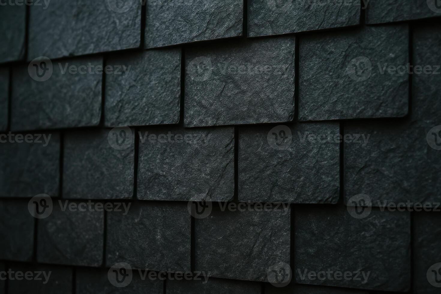 Dark grey rectangular stone cladding tiles on a wall with overlapping pattern and rough texture photo
