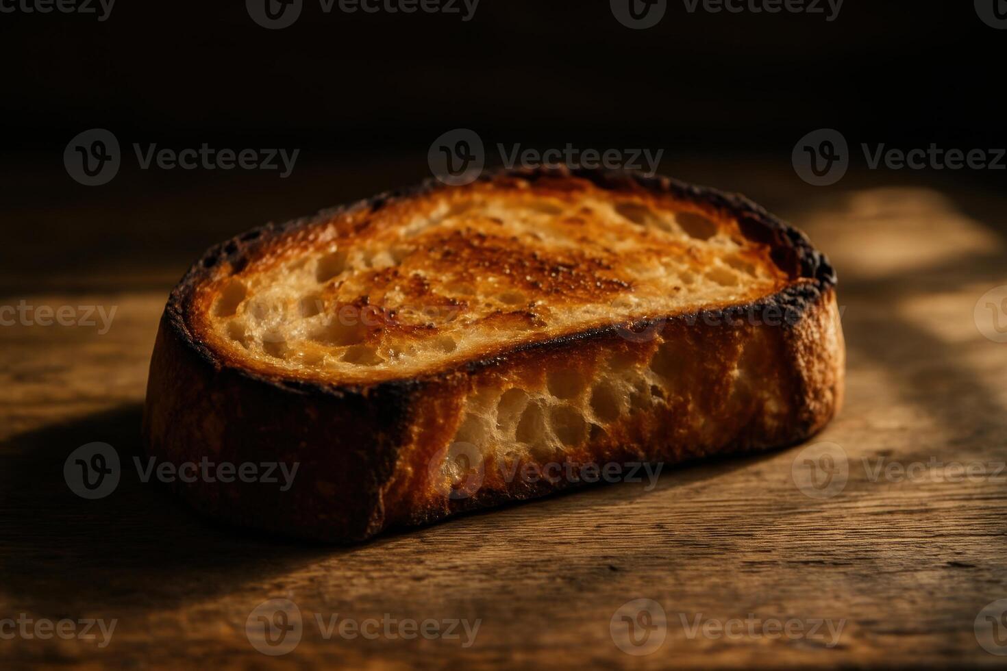 Close up of a single slice of toasted sourdough bread on a rustic wooden table photo