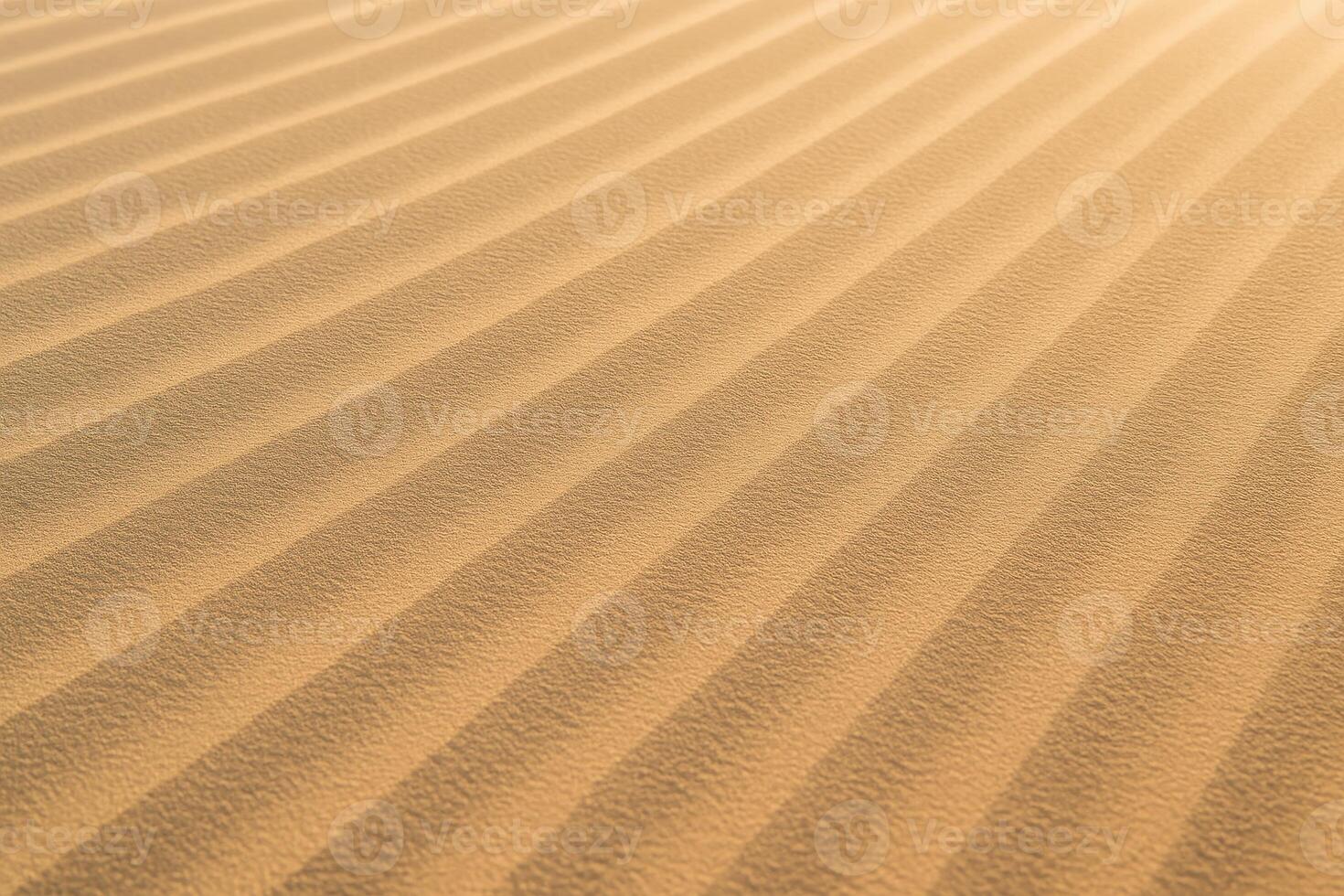 Detailed texture of golden desert sand with parallel lines and natural patterns photo