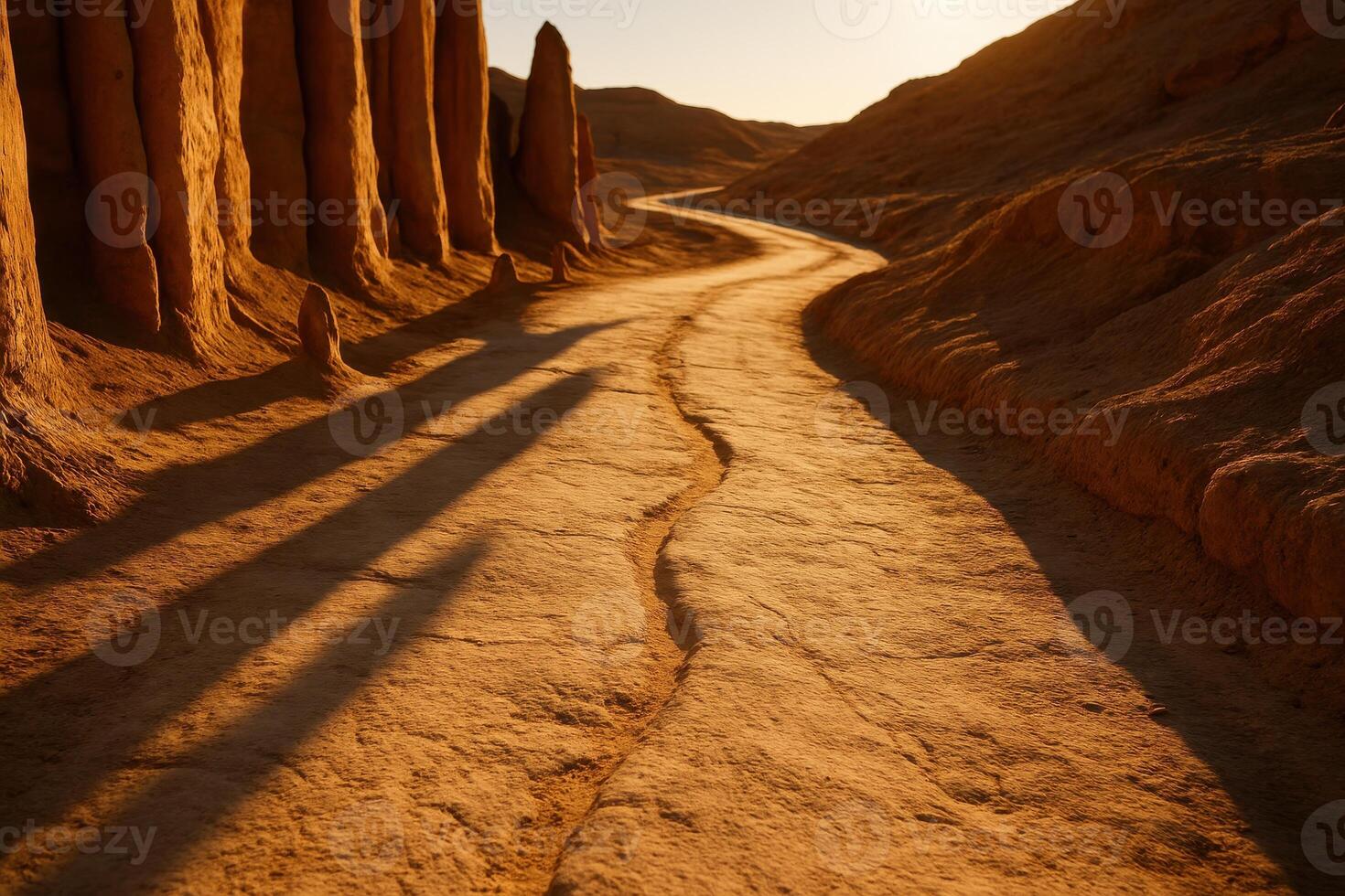 Sunlit winding desert path through sandstone formations with long shadows photo