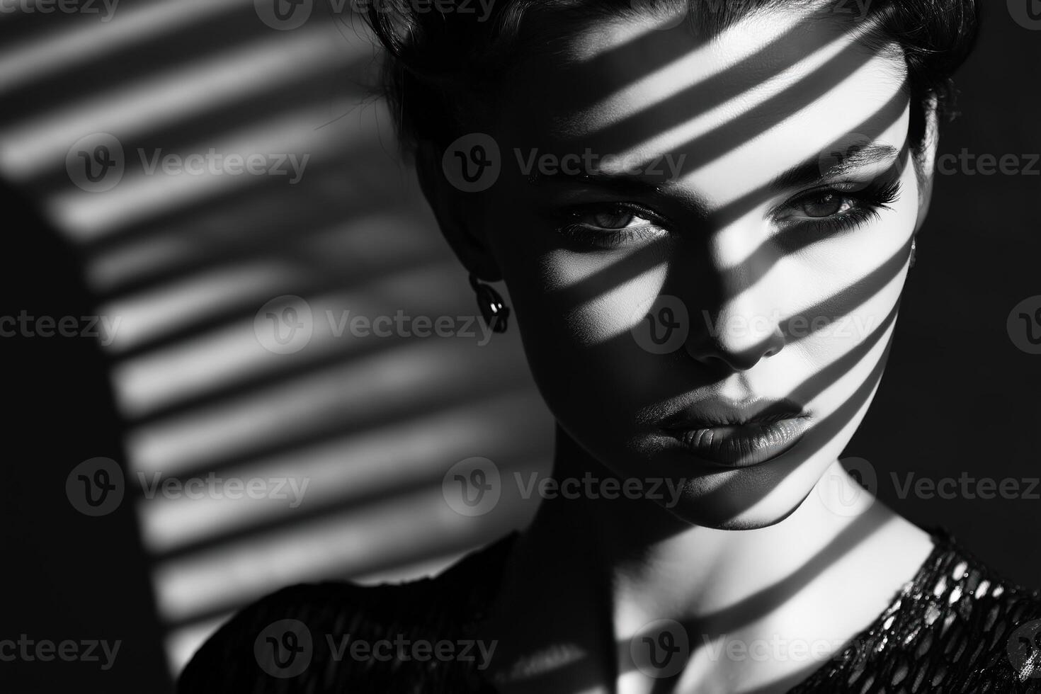 Fashion model posing with dramatic light and shadow stripes on face photo