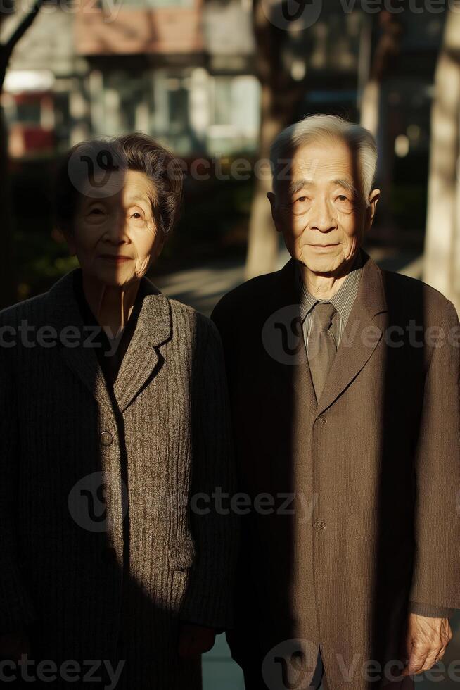 Elderly japanese couple posing in warm sunlight with shadows photo