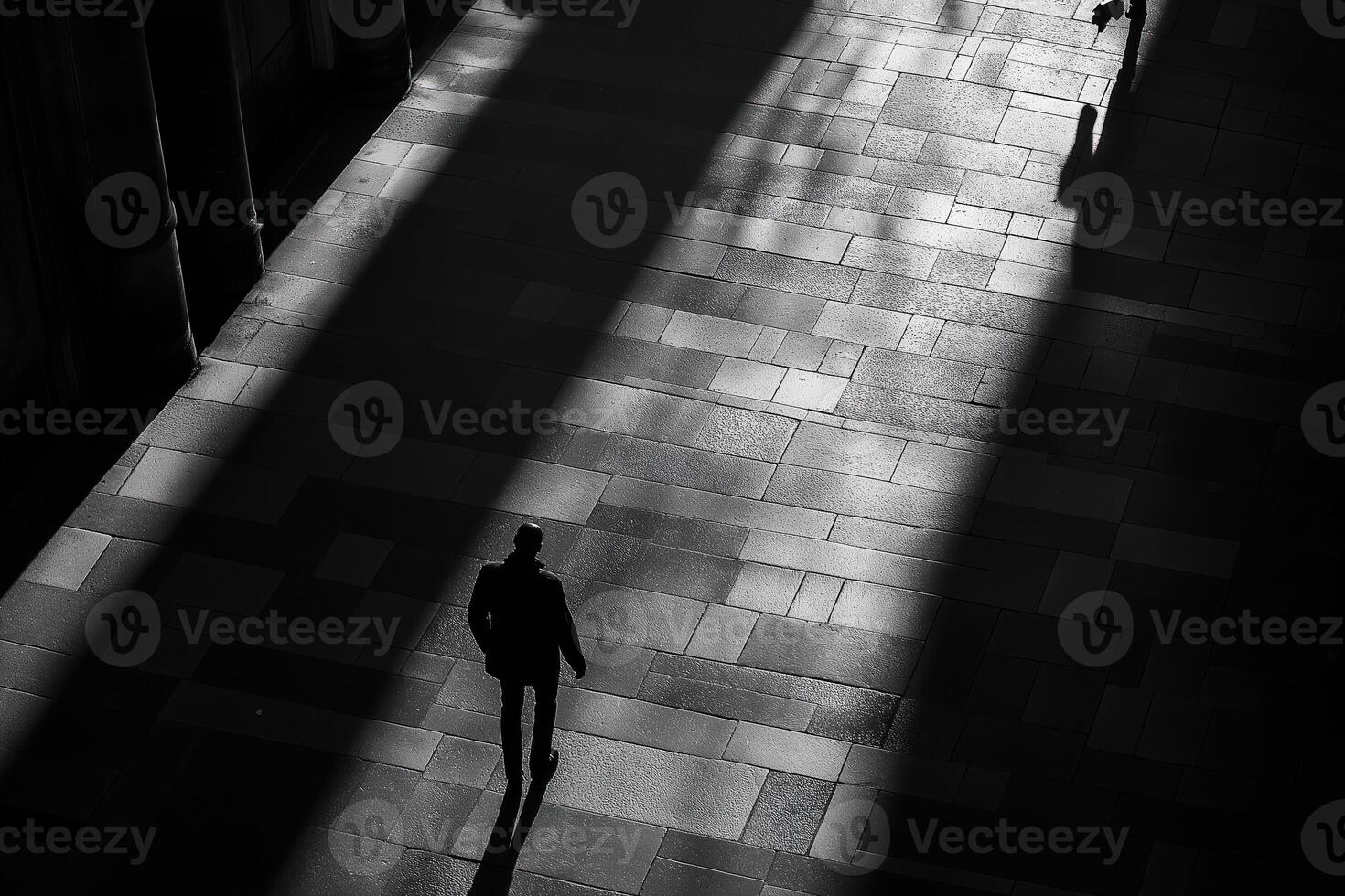 Businessman walking in corridor with light beams and shadows photo