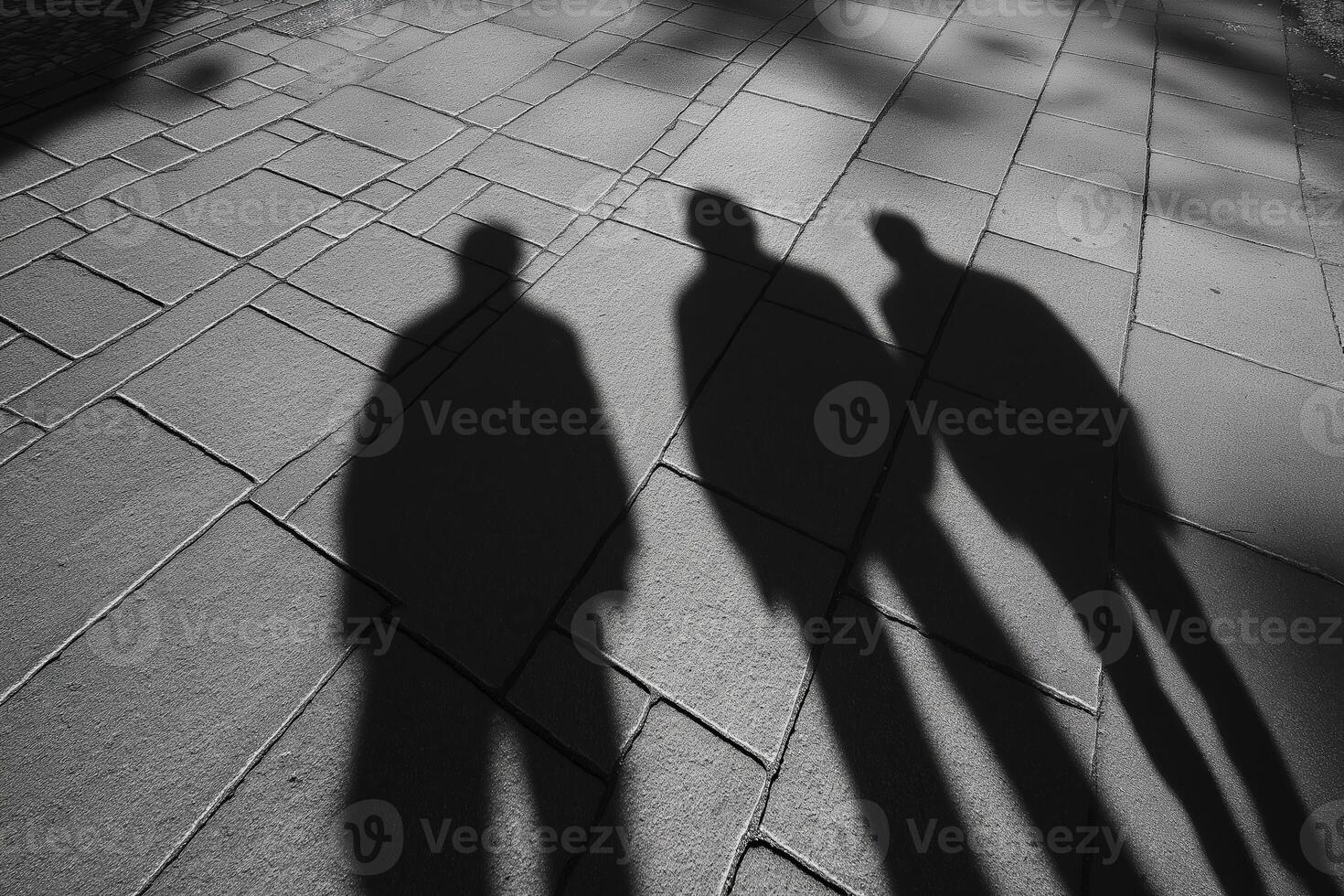 Three men walking together casting long shadows on sidewalk photo