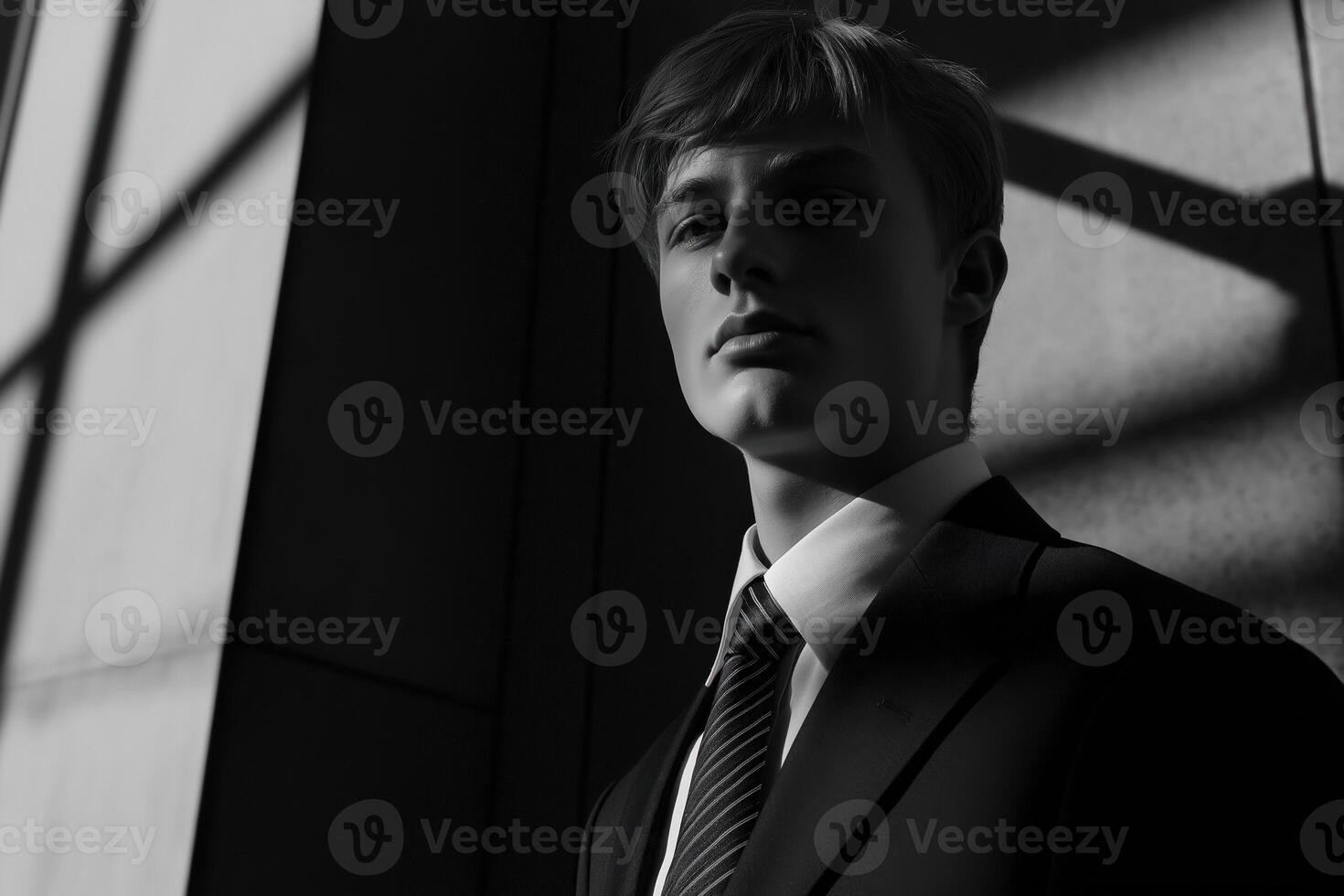 Serious businessman posing in office building with dramatic lighting photo