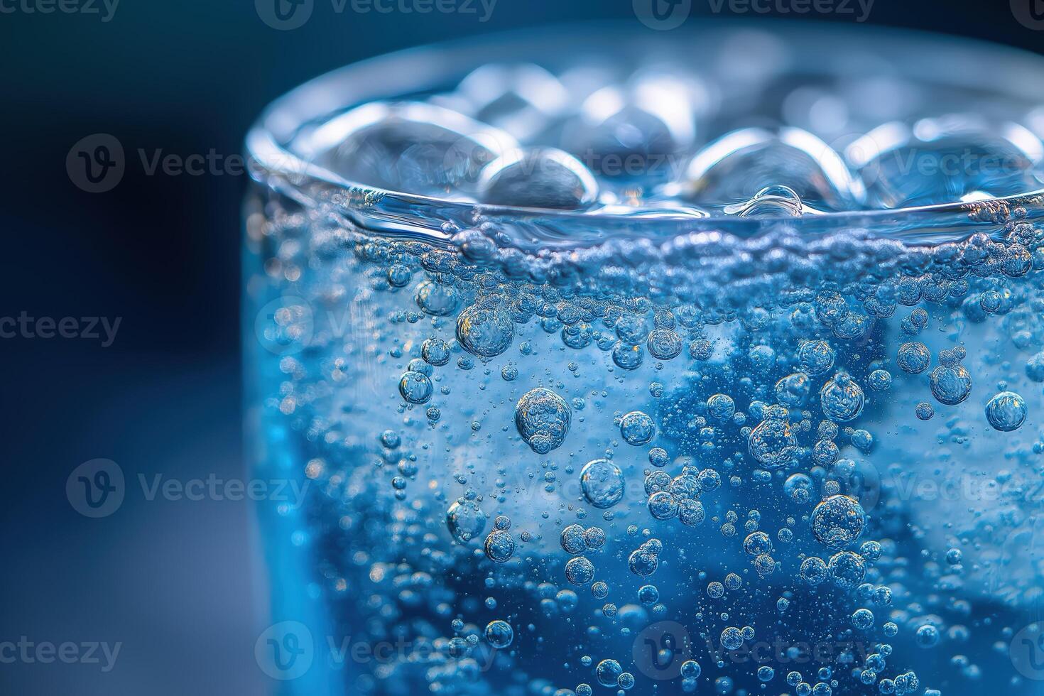 Glass of sparkling water with bubbles rising to surface photo