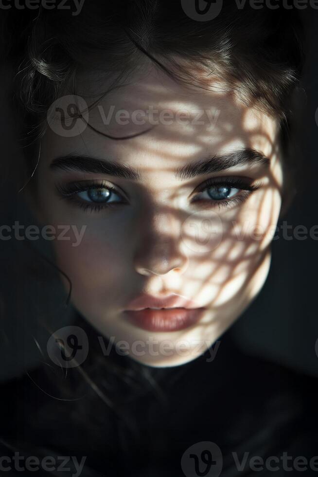 Fashion model posing with dramatic light and shadow on face photo