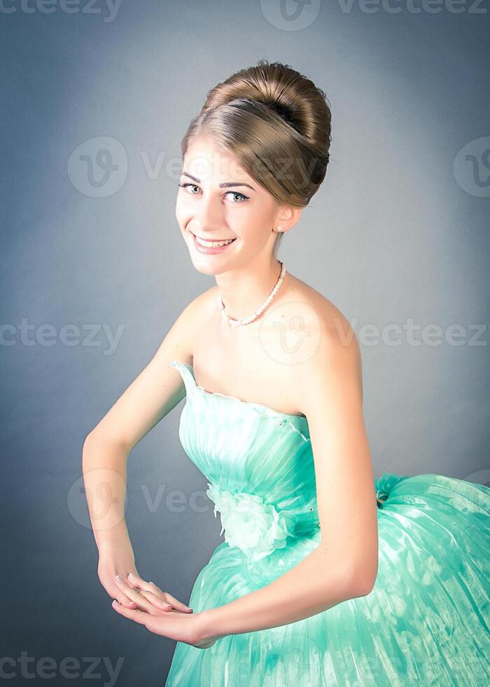 A woman in a green dress is smiling for the camera photo