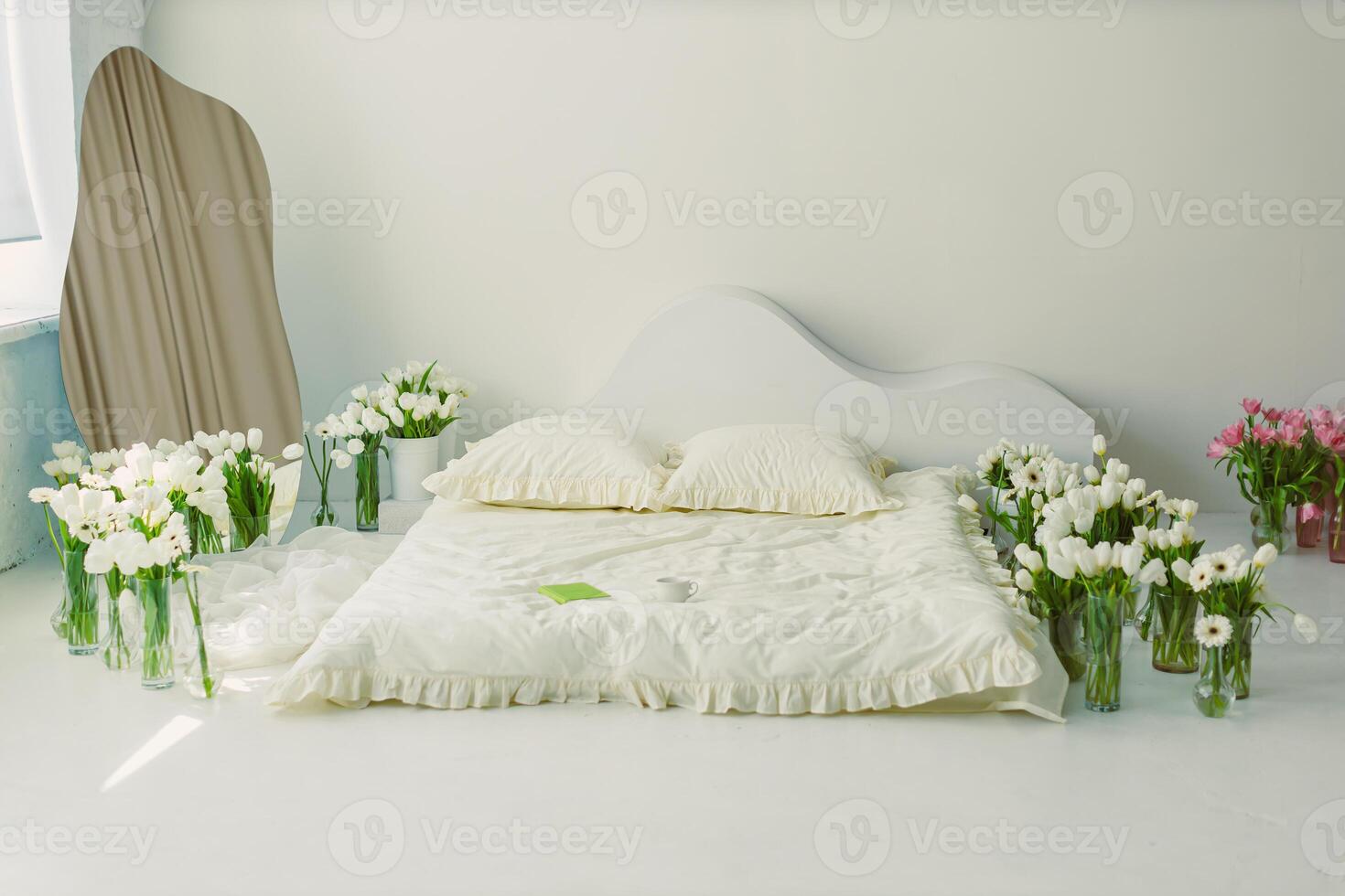 A beautifully serene minimalist bedroom that features fresh flowers adorning the space and soft, inviting bedding, creating a harmonious and tranquil environment that is both modern and elegant photo