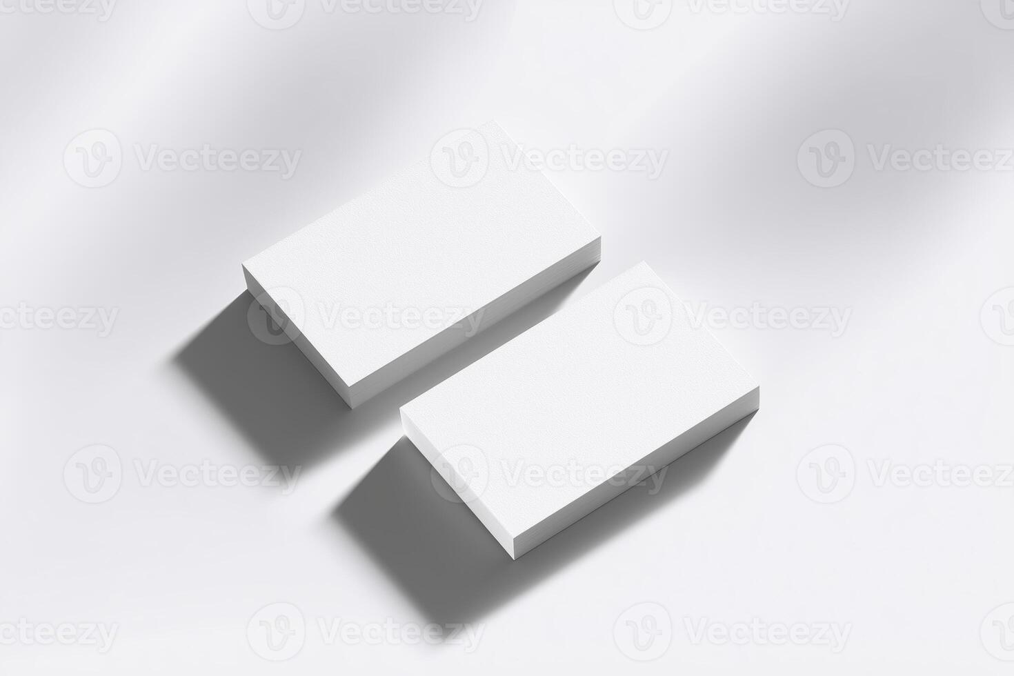 Two blank business cards stacked on a soft white surface, casting subtle shadows, ideal for branding mockups and design presentations with copy space photo