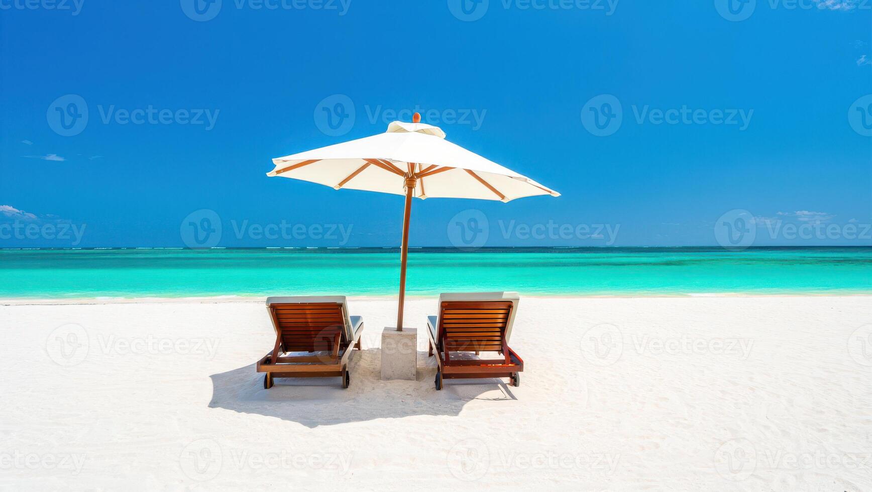 Idyllic Beach Scene with Lounge Chairs Umbrella White Sand and Turquoise Ocean Under a Blue Sky photo