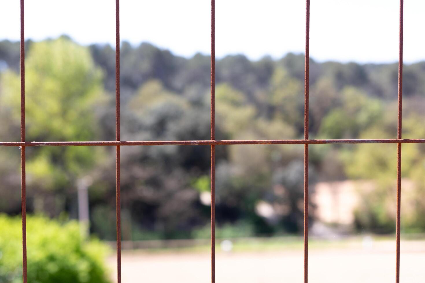 A view of a fence with a view of a field photo