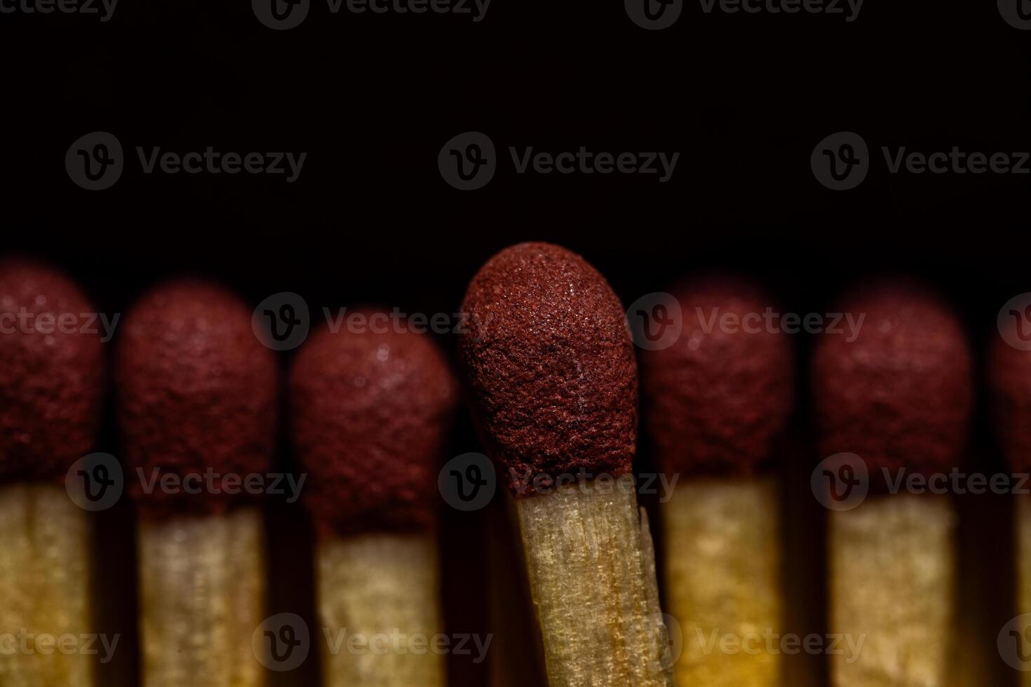 Dramatic Macro Close-Up of Red Matchstick Heads in Dark Setting photo