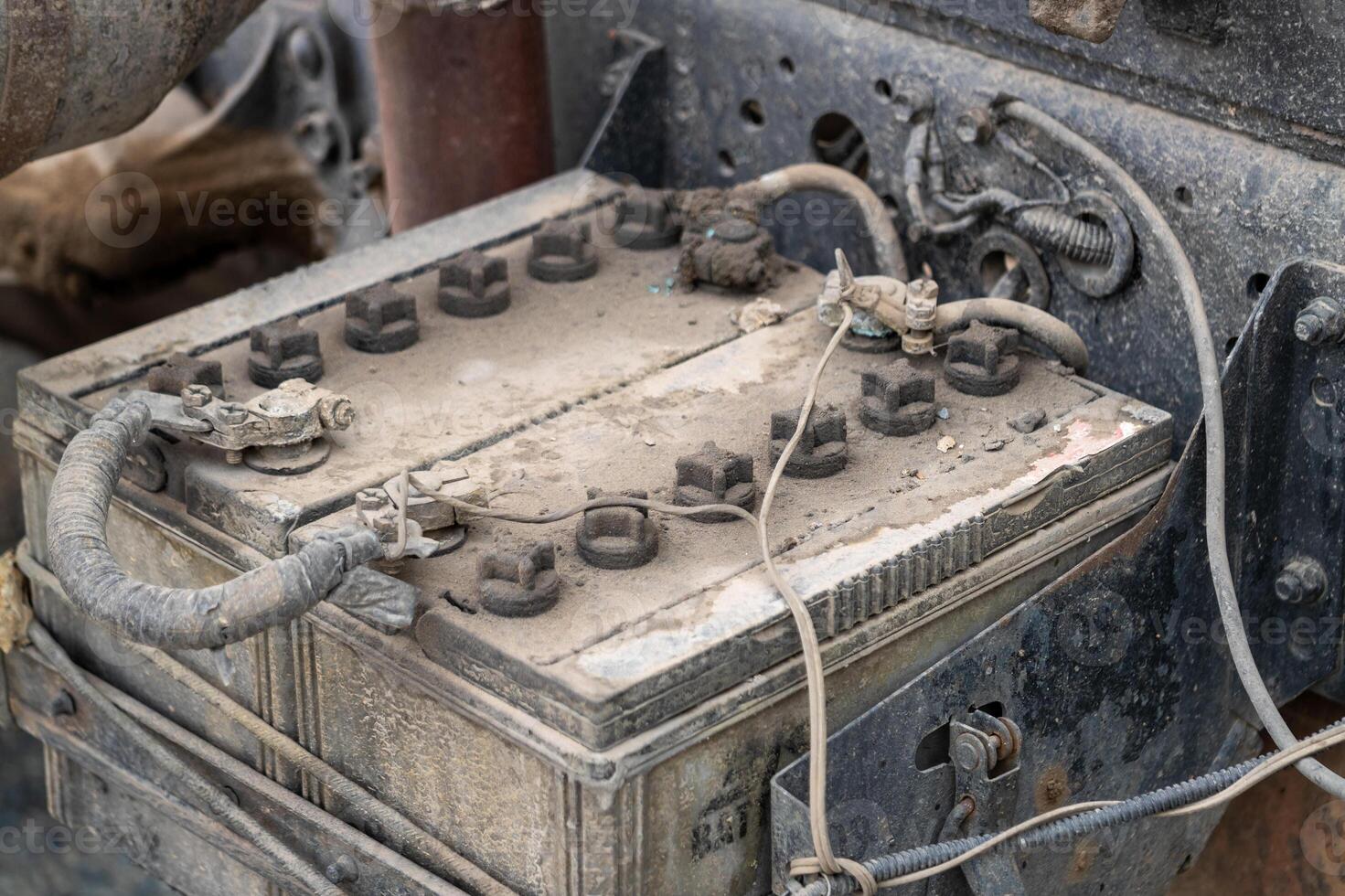 Close-up inspection of old vehicle batteries in industrial garage maintenance setting photo