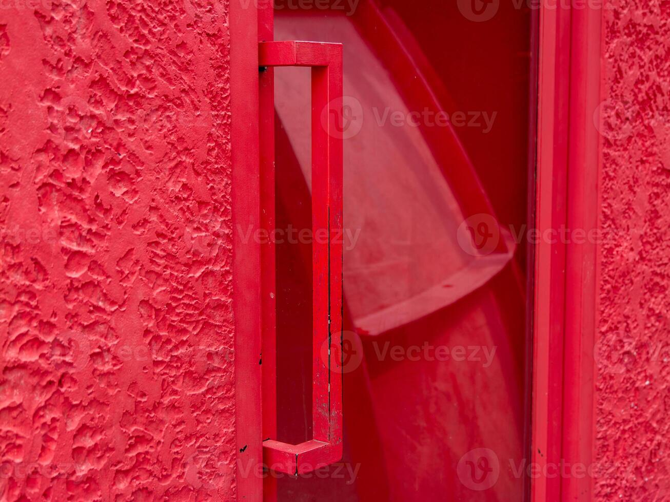 Red door handle urban setting close-up vibrant environment artistic perspective photo