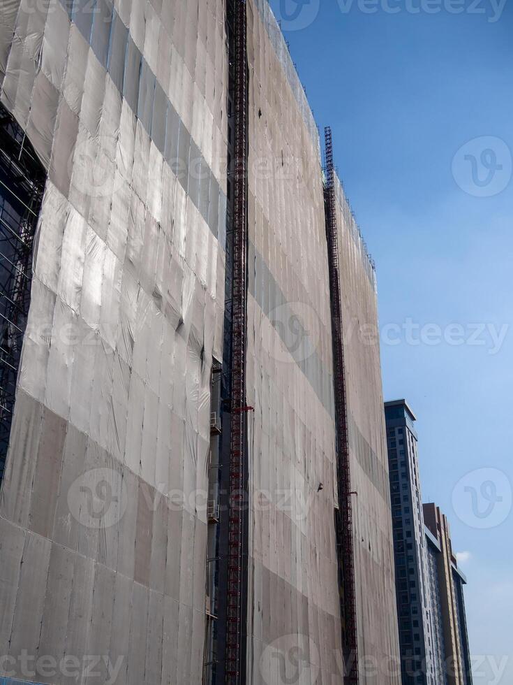 Construction workers scaling building facade urban cityscape high-rise environment safety focus photo