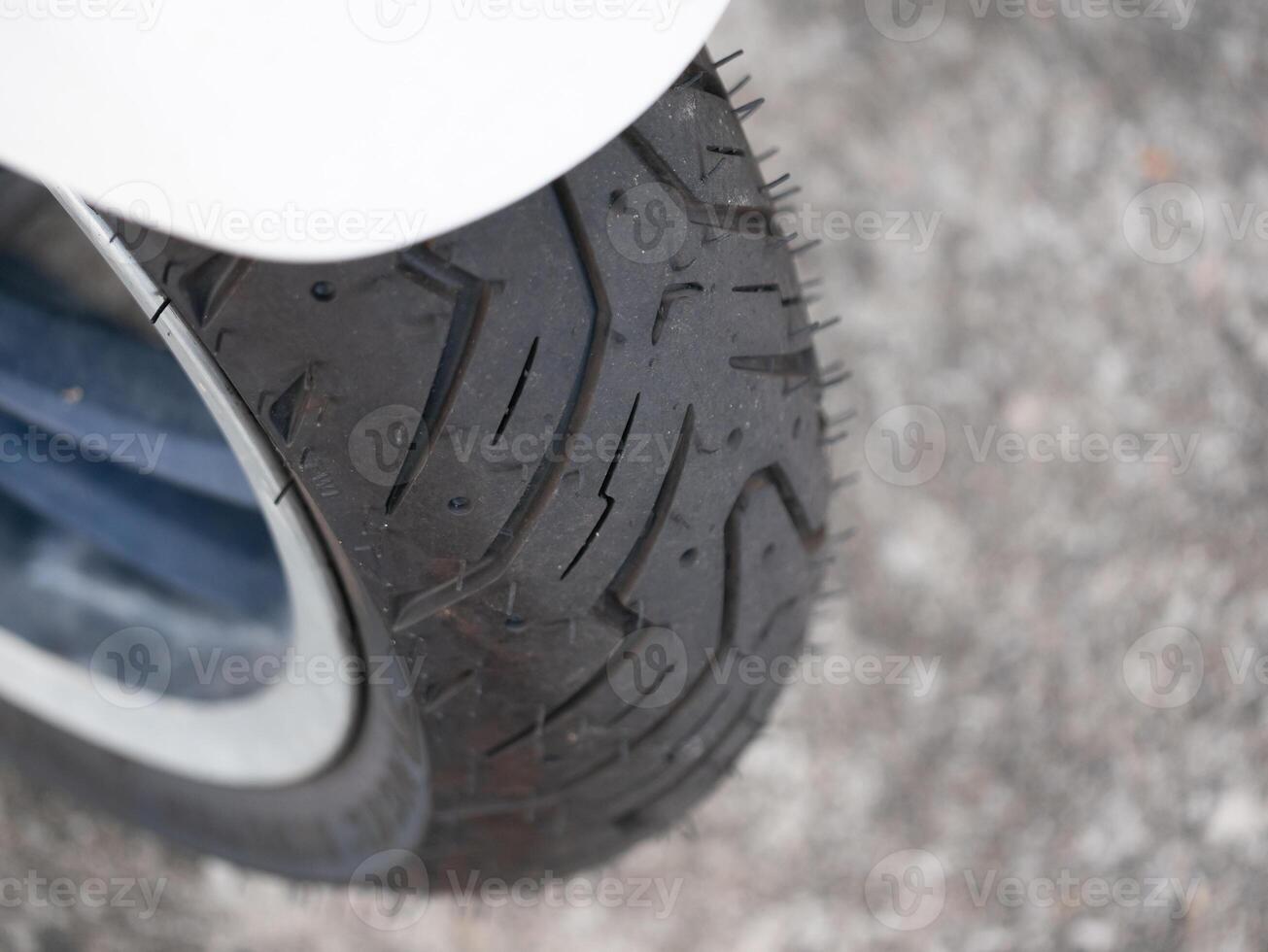 Detailed close-up of a motorcycle tire on asphalt urban environment automotive photography low angle durability concept photo
