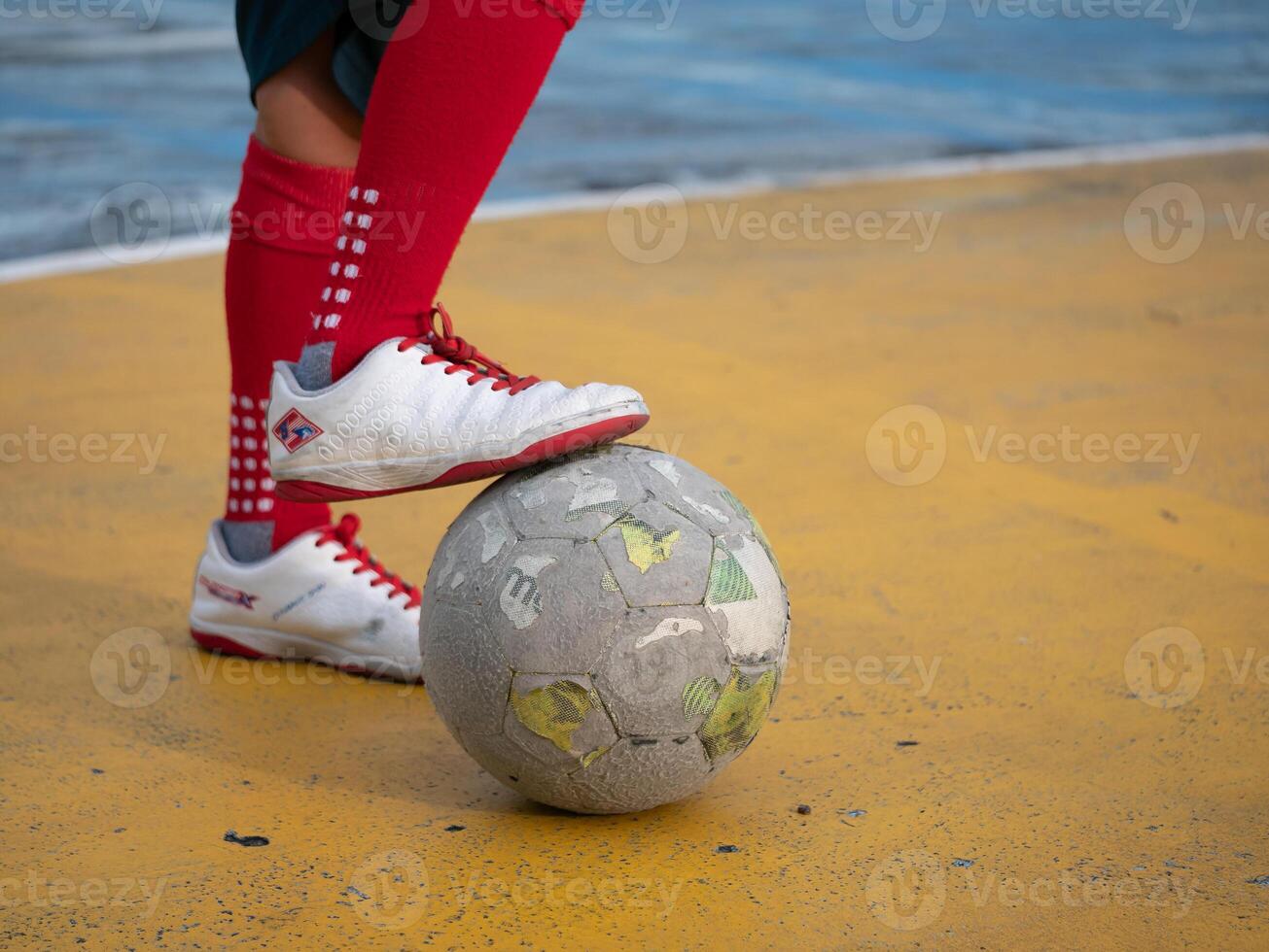 Soccer player balancing on a ball urban playground sports action outdoor close-up view athletic skill development photo