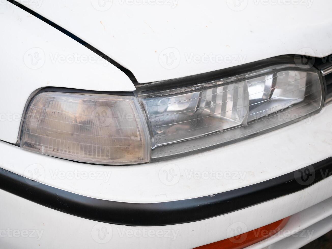 Car headlight close-up urban setting automotive photography daylight detailed view vehicle maintenance insight photo