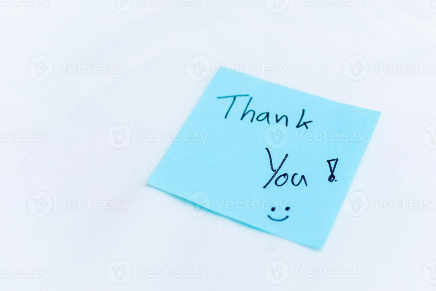 Thank you note on blue sticky pad office setting personal gesture clean environment close-up view concept of appreciation in business photo