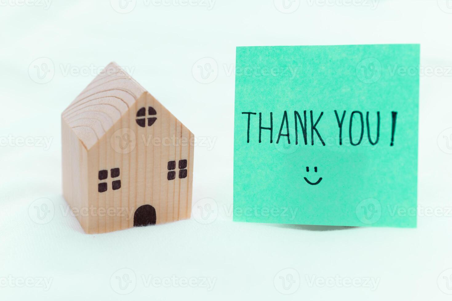 Thank you note next to wooden house model home office emotional content minimalist setting close-up view business appreciation photo