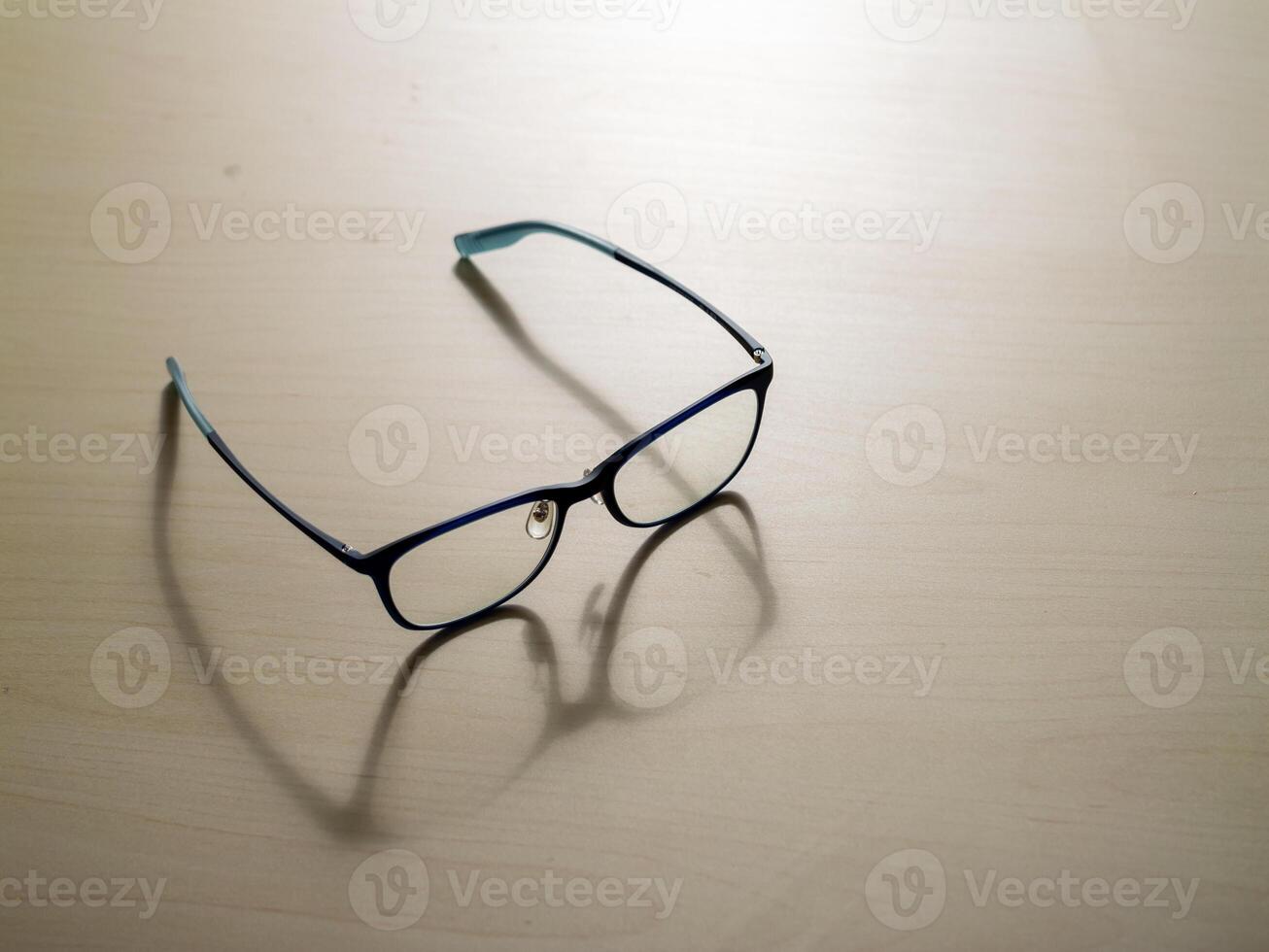 Stylish eyeglasses on wooden surface close-up view modern design minimalist aesthetic photo