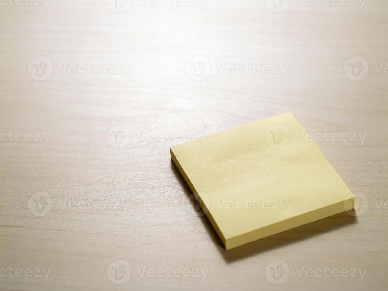 Minimalist office setting yellow sticky note on wooden desk for creative productivity photo