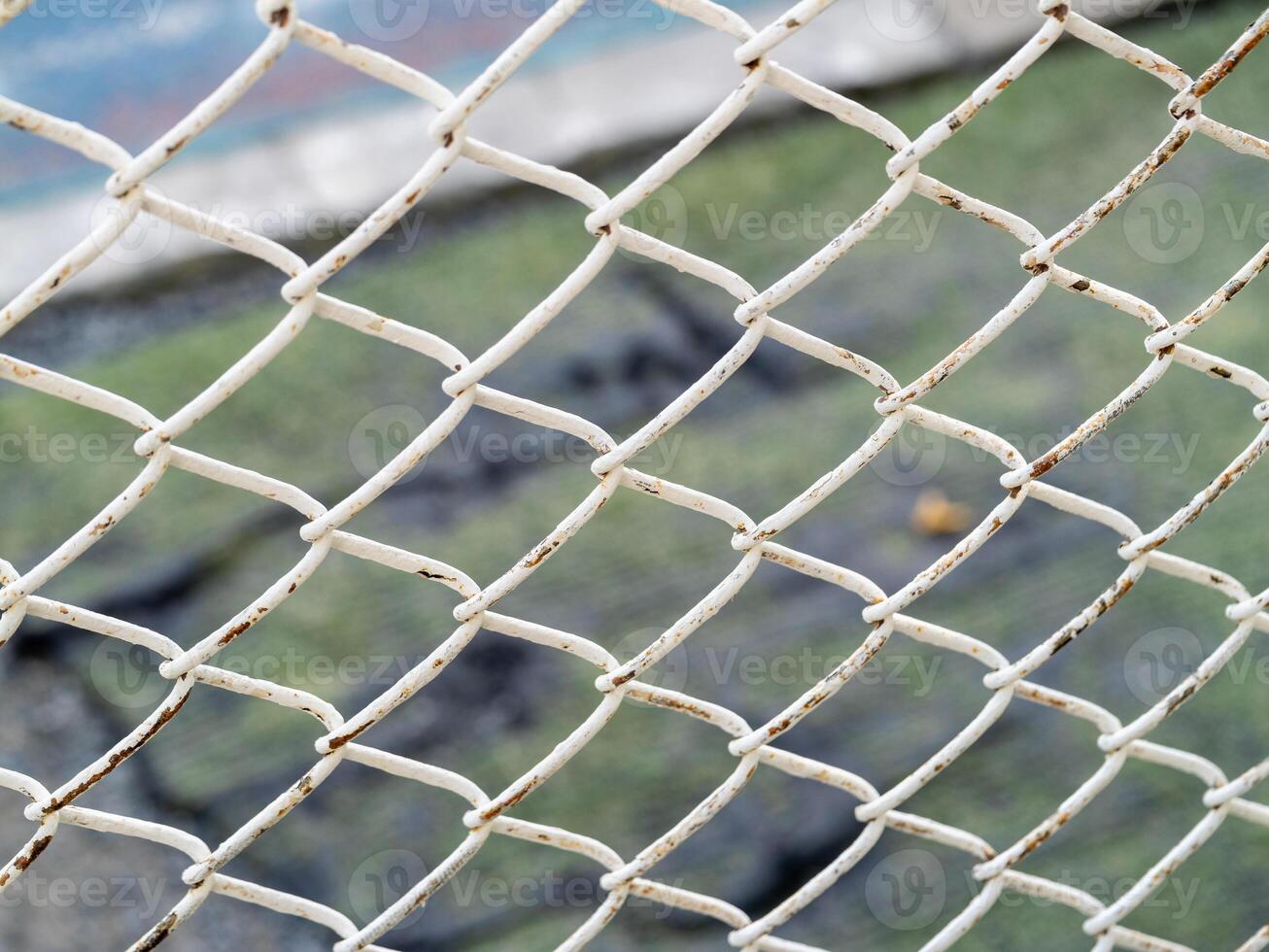 Rusty white chain link fence urban environment close-up abstract view texture exploration photo