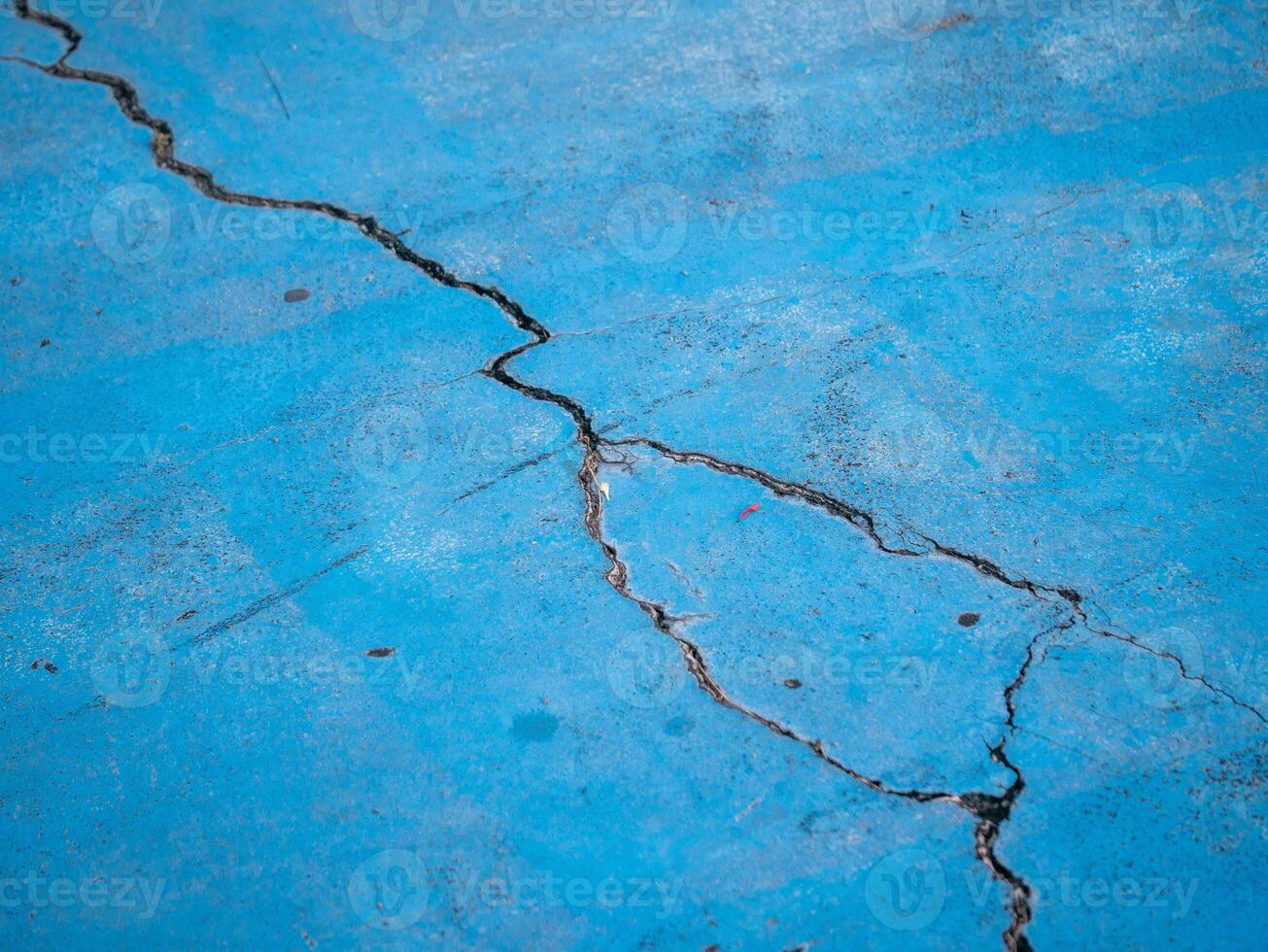Cracked blue surface urban setting close-up industrial environment ground level texture analysis photo
