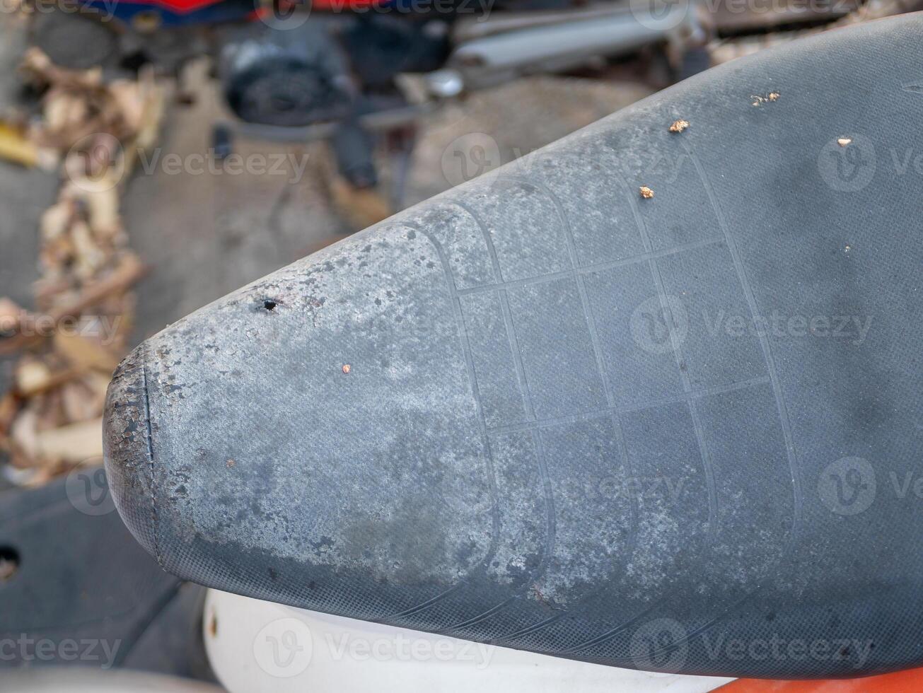 Outdoor workshop focus motorcycle seat maintenance industrial ground-level detail photo