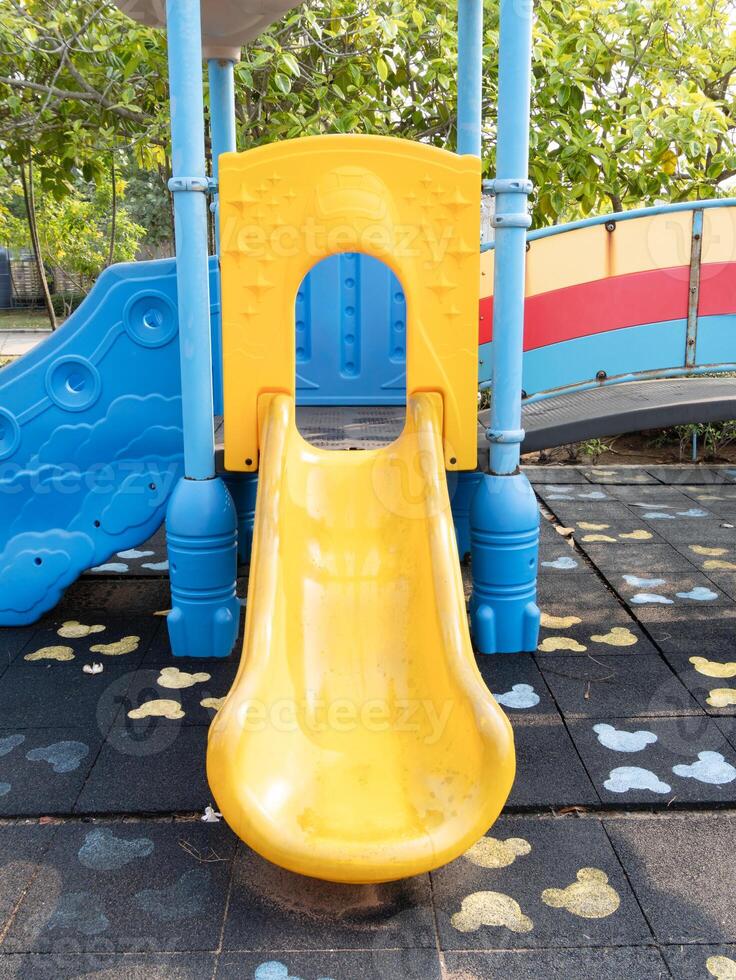 Children playing yellow slide at playground outdoor fun vibrant environment bird's eye view photo
